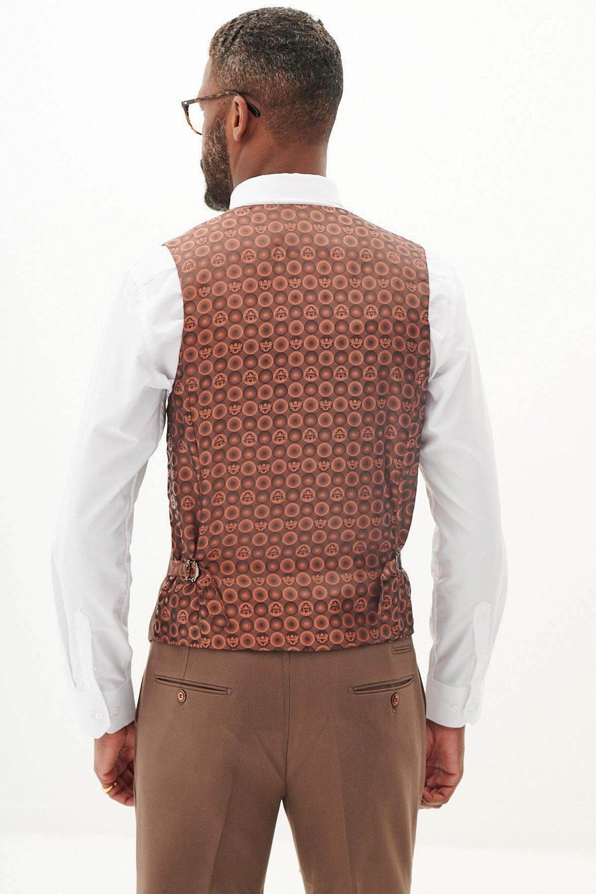 A man models the Marc Darcy West Bromwich Albion F.C. Collection | HM5 Tan Tailored Suit as seen on Michael Johnston, featuring a white shirt and brown vest with marbled buttons, standing against a plain white background.