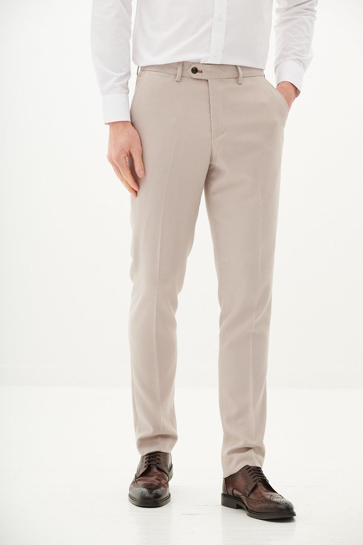A man wears a marcdarcy KRIS Silver Grey Tweed Blazer paired with HM5 Stone Trousers, one hand in his pocket and dark brown dress shoes.