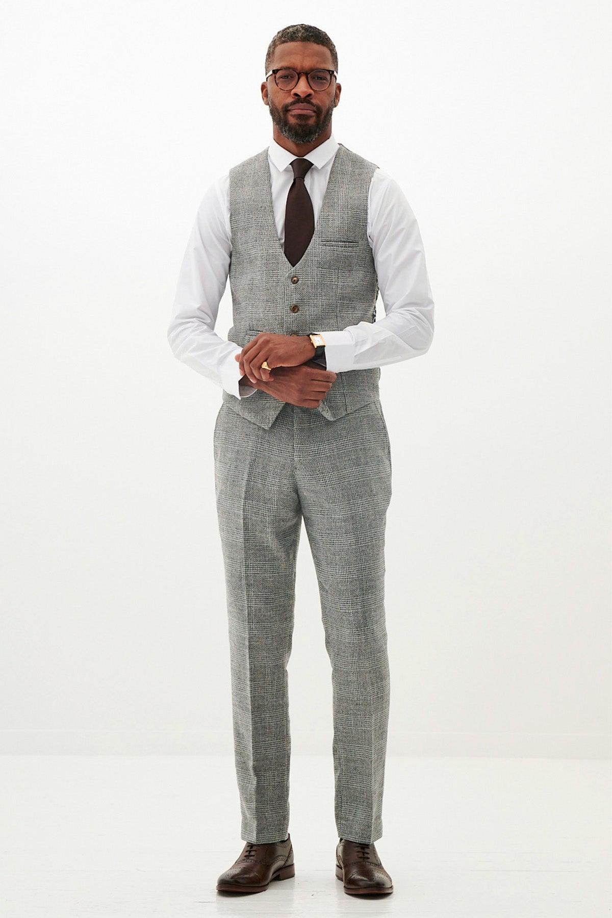 A man wears the marcdarcy KRIS Silver Grey Tweed Suit with a white shirt and brown tie, standing against a white background.