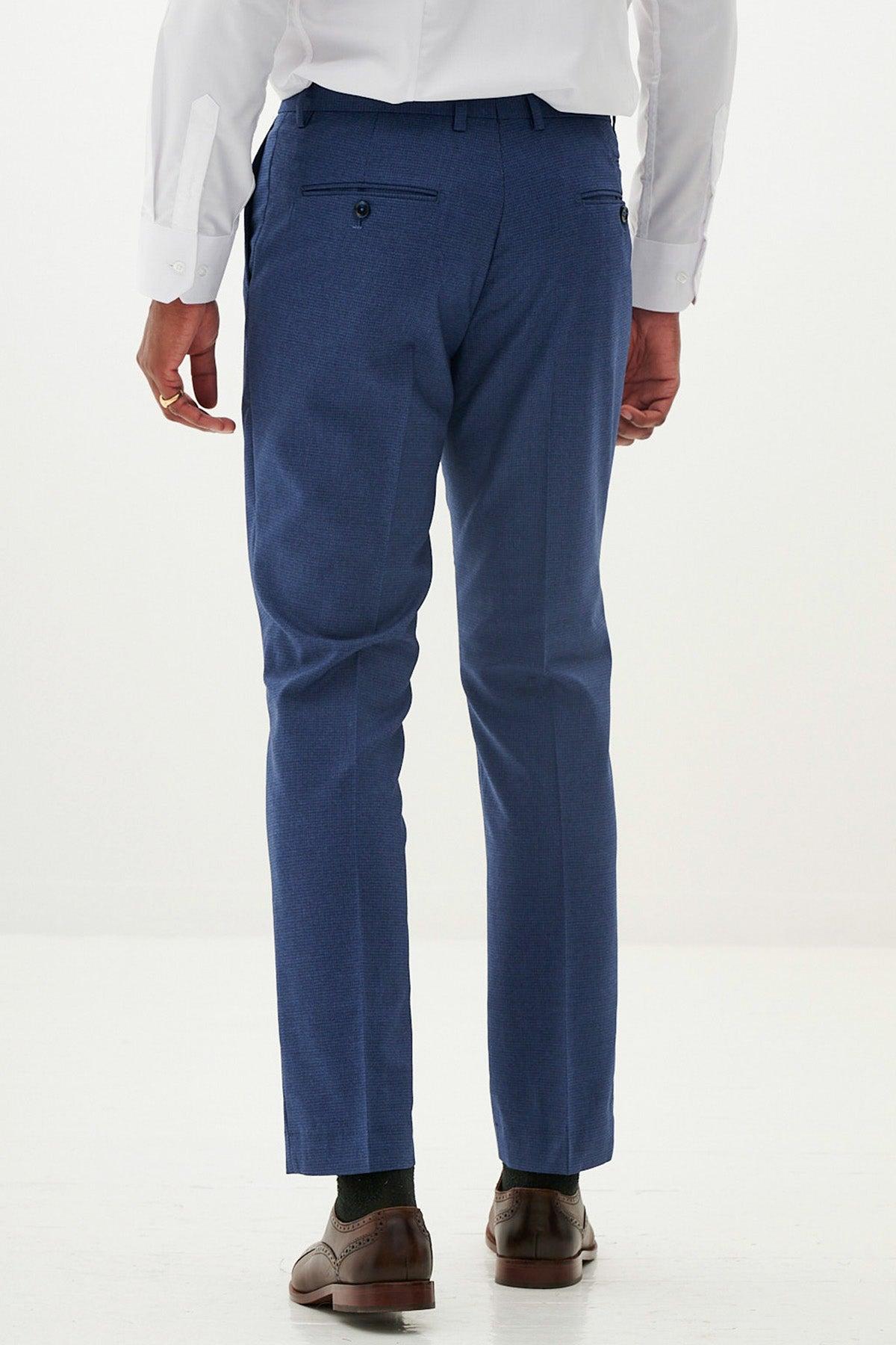 A person wearing the ASHLEY - Navy Blue Trousers by Marc Darcy, paired with a white dress shirt and brown dress shoes, stands with their back to the camera against a plain light background.