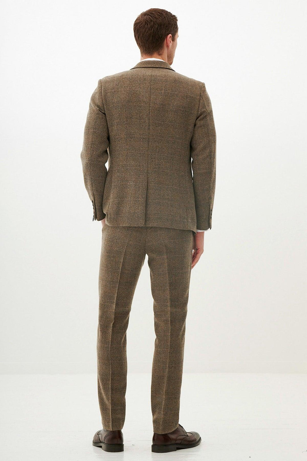 A man faces away from the camera, wearing the marcdarcy KRIS Tan Tweed Three Piece Suit with matching trousers and brown shoes, set against a plain white background.