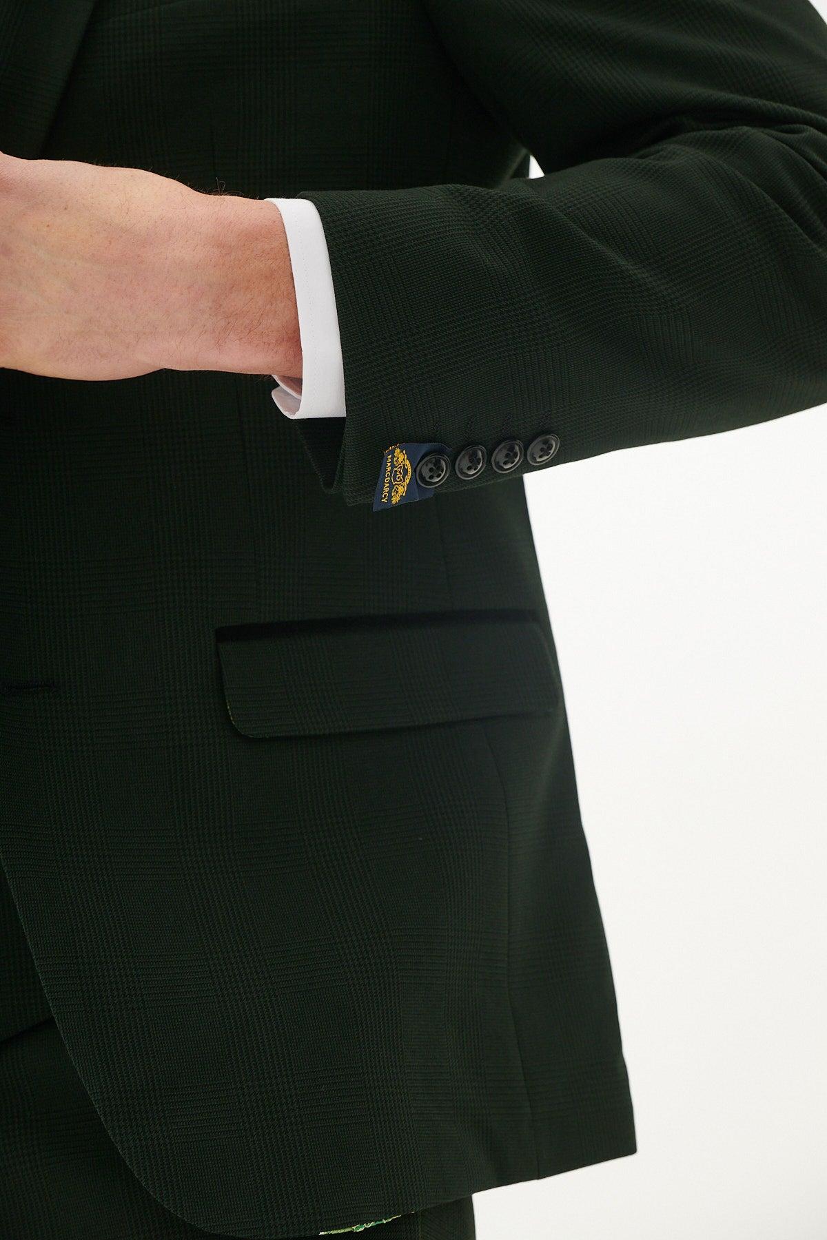 A close-up of former Wolverhampton Wanderers footballer George Berry in a Marc Darcy Bromley Olive Green Suit, showing his arm, white shirt cuff, black sleeve buttons, and partially visible hand against a plain white background.