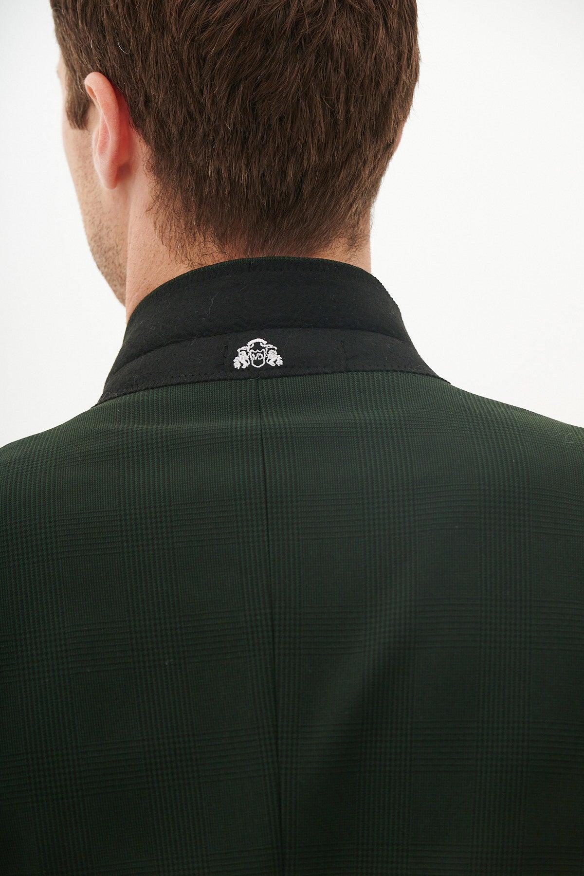 A person with short brown hair is seen from behind, wearing the Marc Darcy BROMLEY Olive Green Check Suit with a Kris Tan Tweed Waistcoat; a small white embroidered design appears on the back of the collar.
