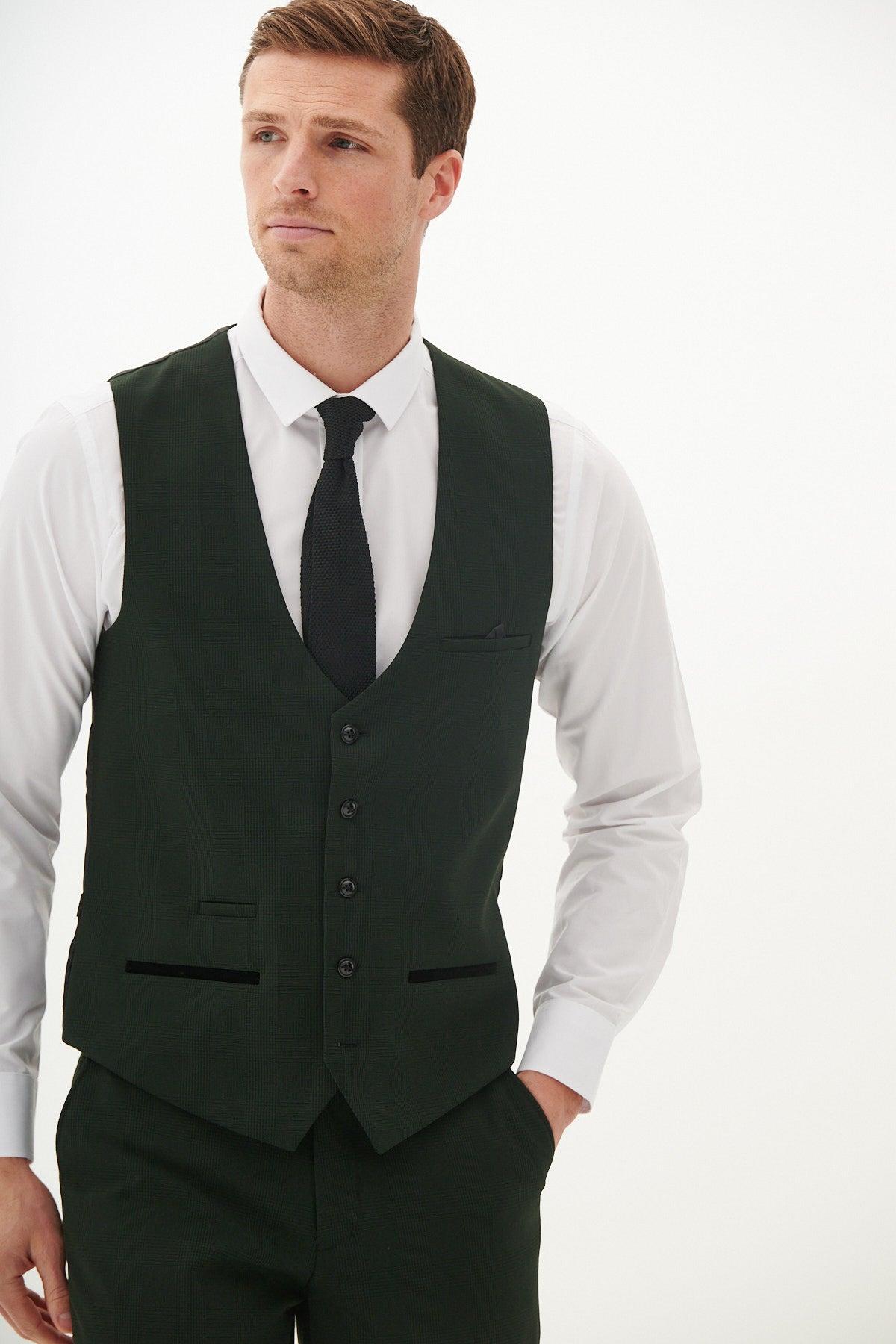 A man wears the Marc Darcy BROMLEY Olive Green Single Breasted Check Waistcoat with matching trousers, a white dress shirt, and a black tie, standing against a plain white background.