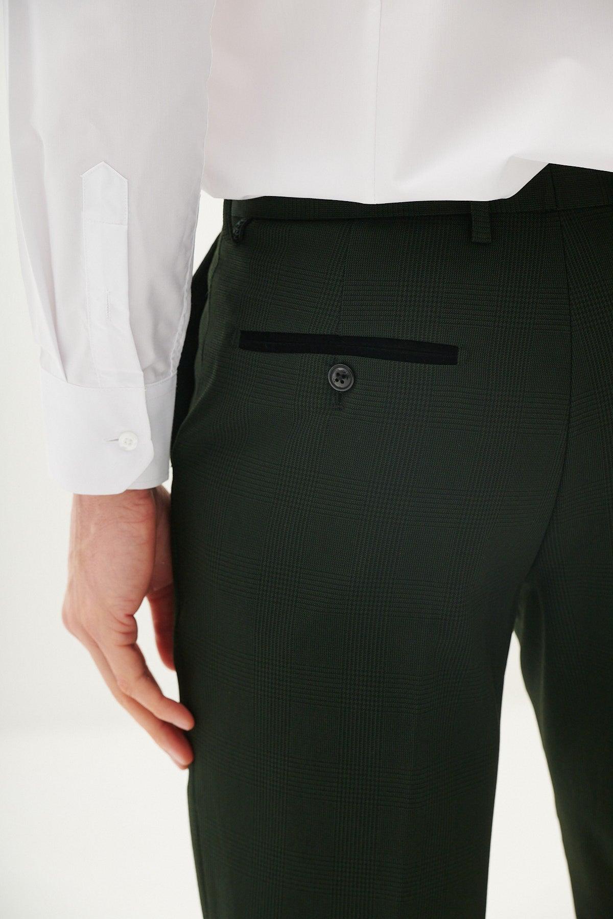 A person wears the Marc Darcy BROMLEY Olive Green Check Suit from The Cardiff City F.C. Collection, as worn by Karlan Grant, shown from the back waist down with one hand by their side and a single buttoned back pocket visible.