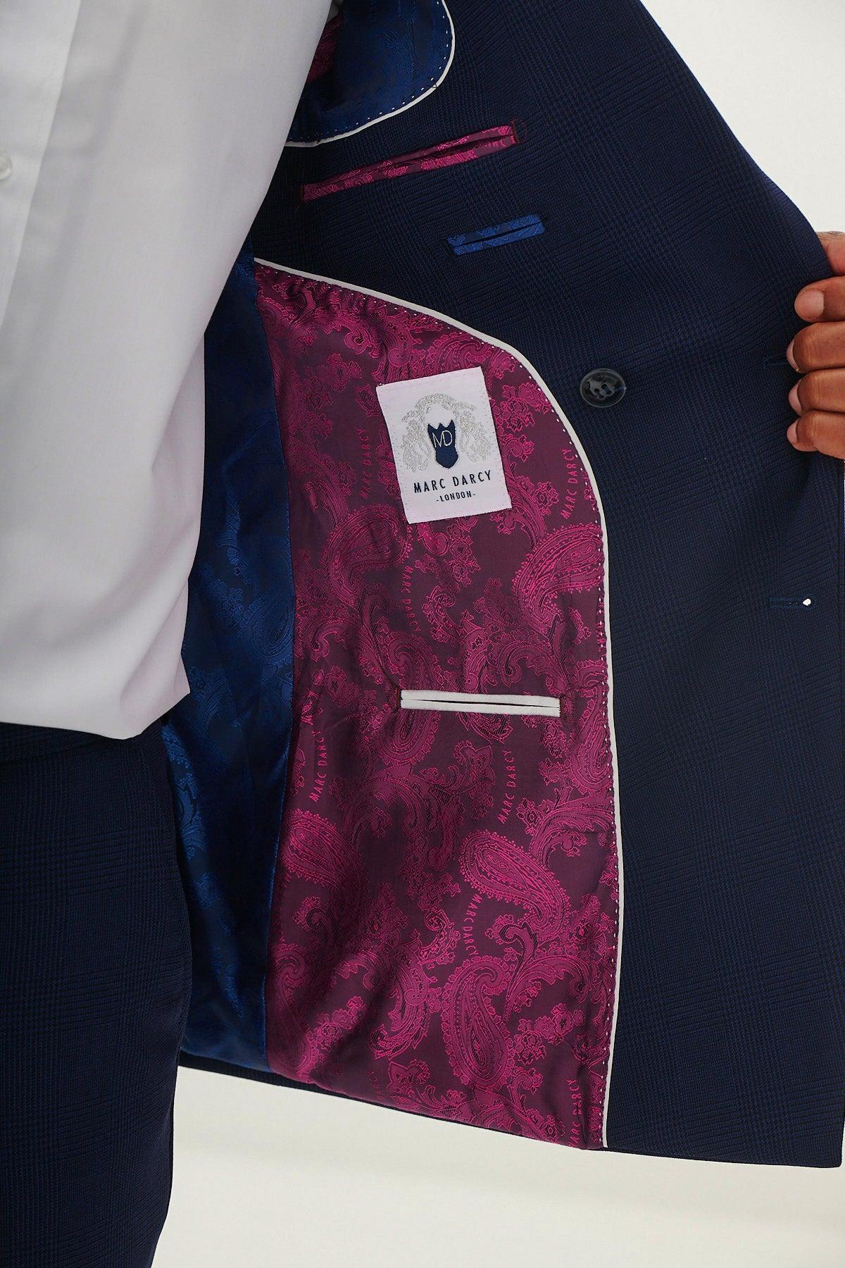 A man opens a BROMLEY - Navy Check Blazer by Marc Darcy, revealing its bold magenta paisley lining and the Marc Darcy label sewn inside.