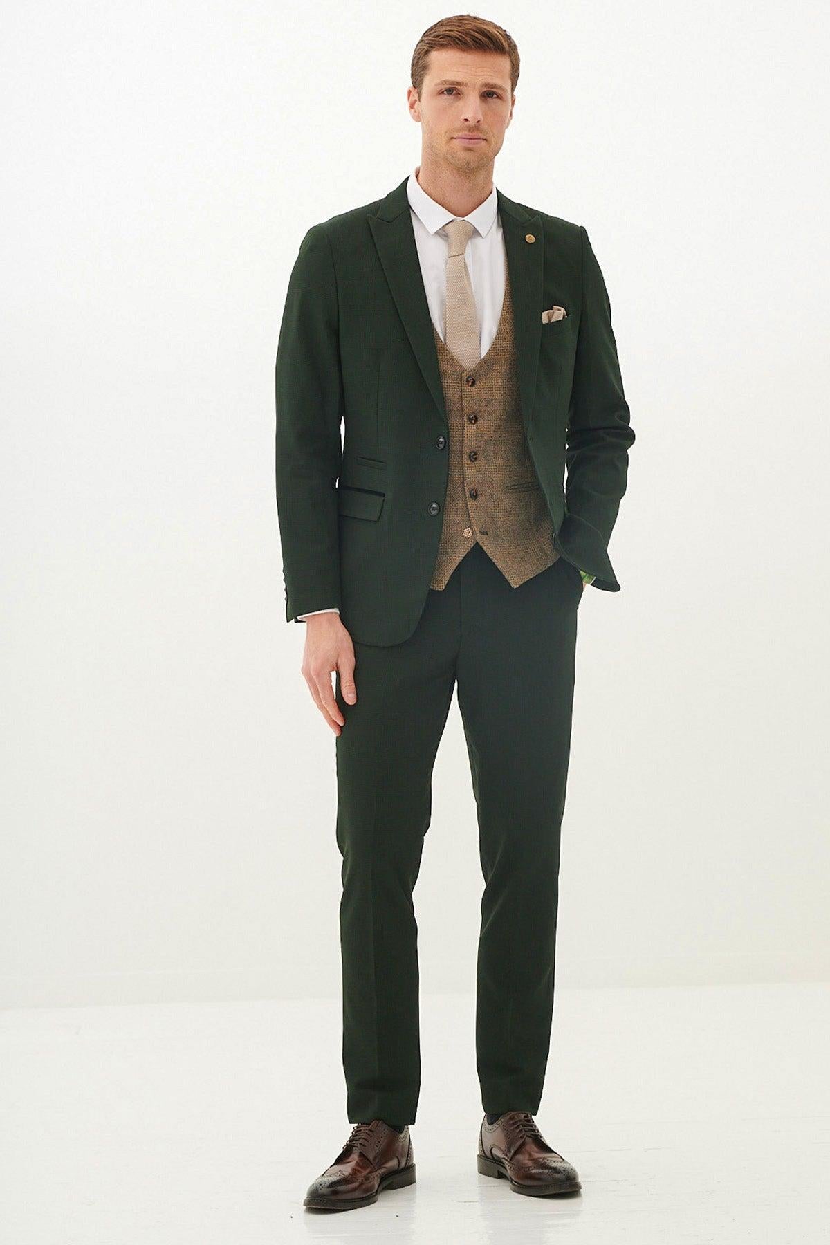 Man wearing the Marc Darcy BROMLEY olive green check suit with Kris tan tweed waistcoat, white shirt, tan tie, pocket square, and brown shoes.