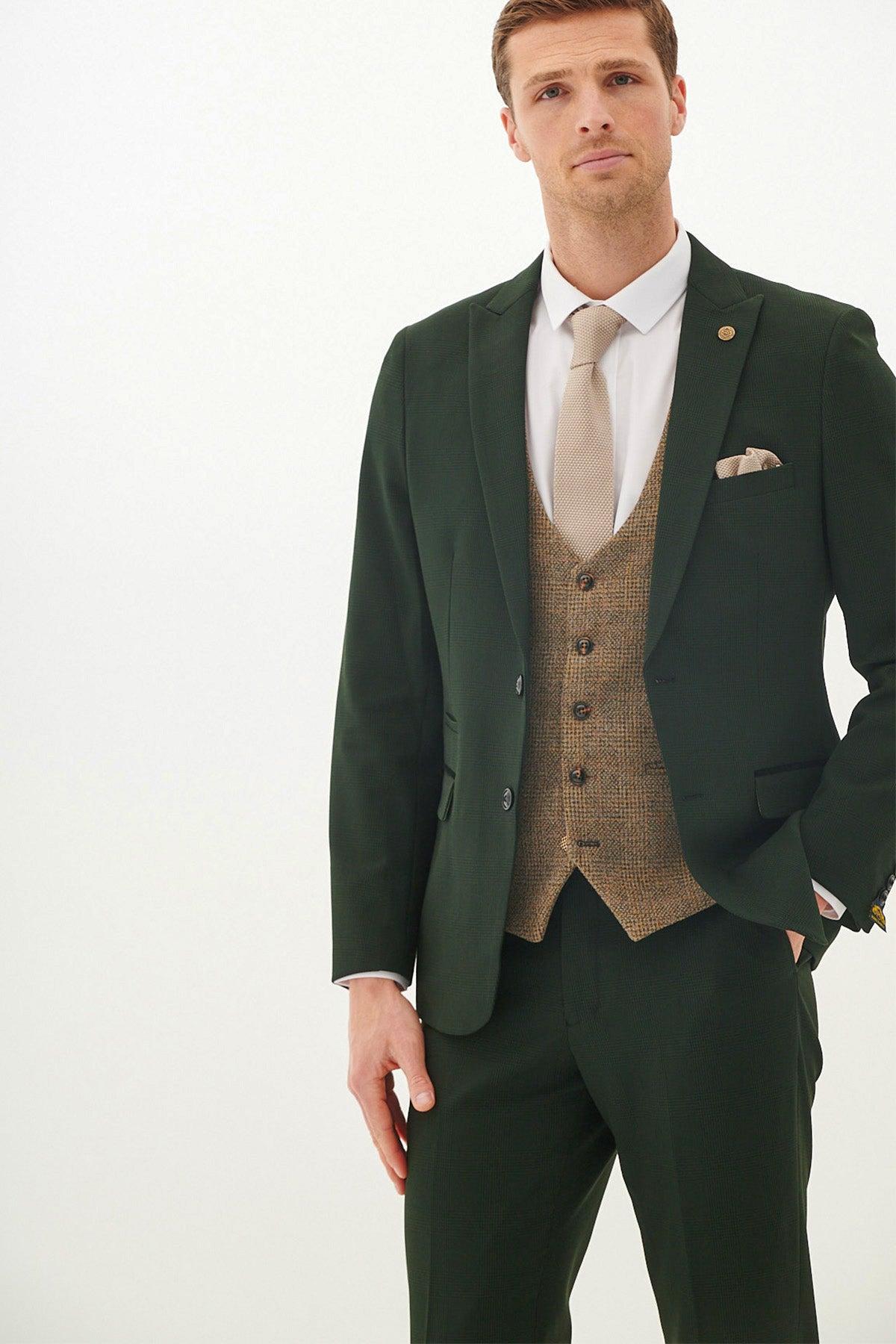 A man wears the Marc Darcy BROMLEY Olive Green Check Suit with a Kris Tan Tweed Waistcoat, paired with a white shirt, tan tie, and pocket square.