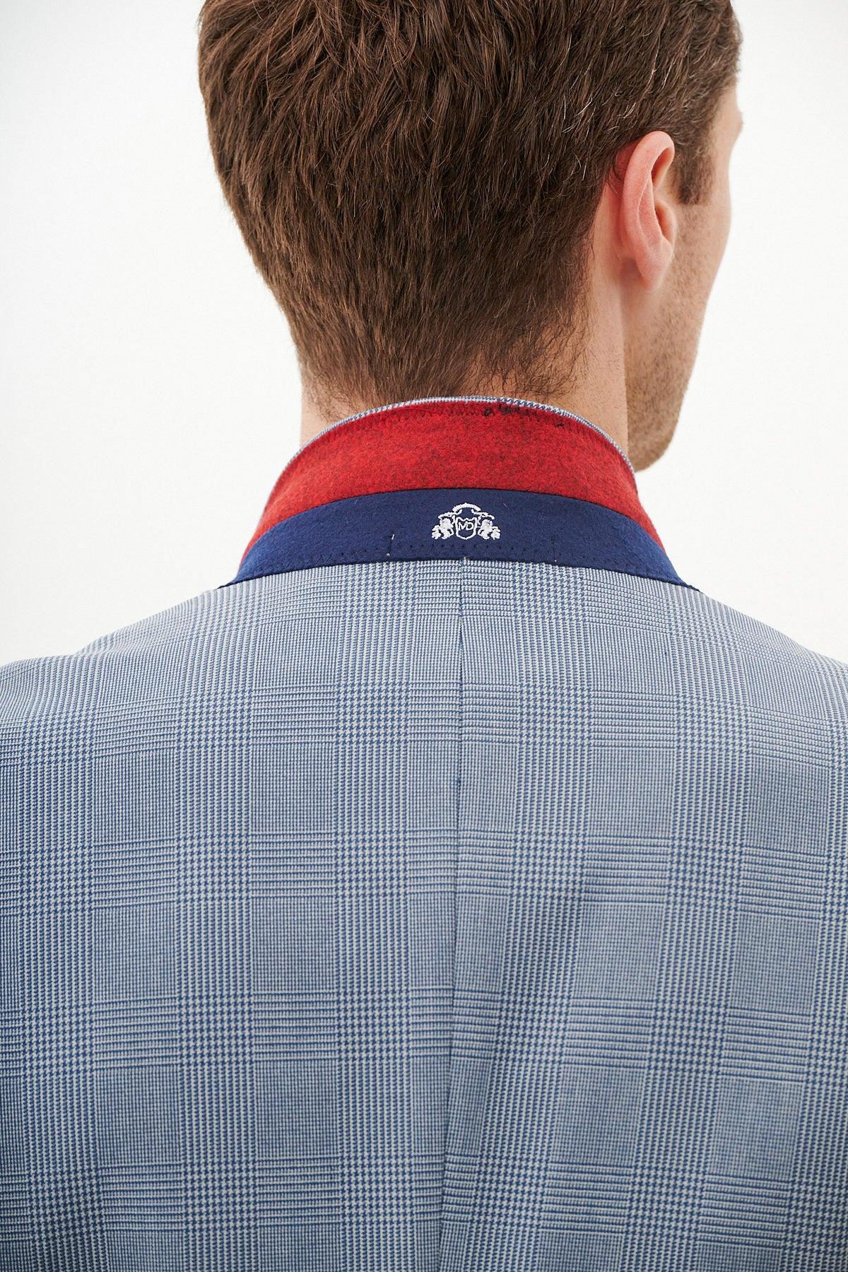A man is seen from behind wearing the Marc Darcy BROMLEY Sky Blue Check Blazer with a red and blue collar featuring a small white embroidered logo at the center, set against a plain white background.