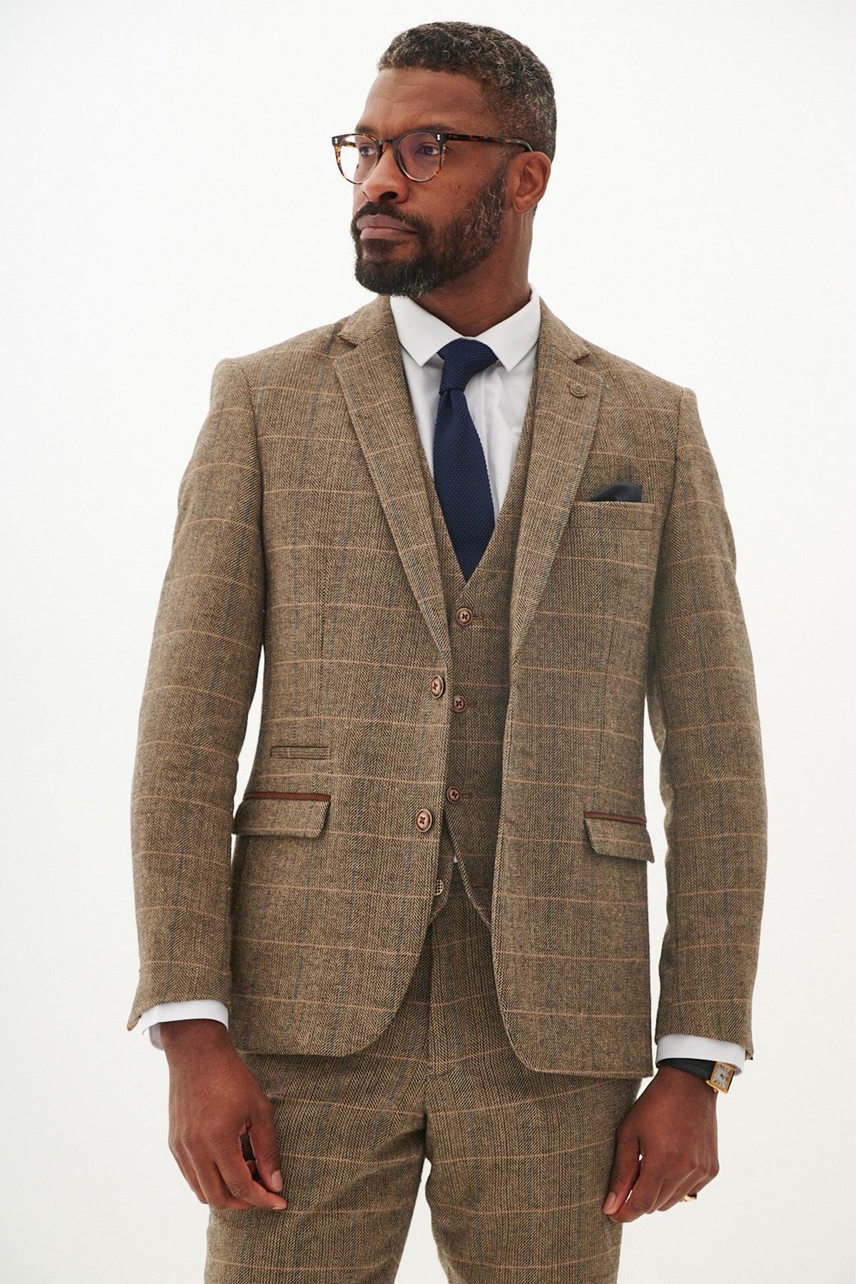 A man with glasses and a beard wears the marcdarcy TED - Tan Tweed Check Blazer as part of a three-piece suit, paired with a white shirt and navy tie.