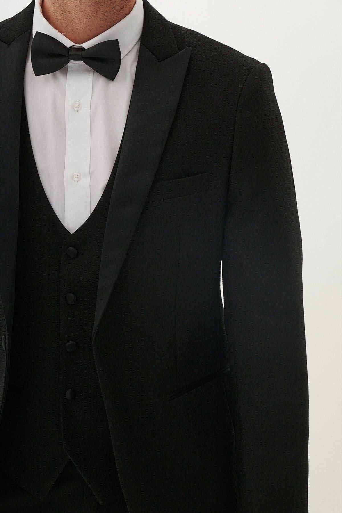 A man wears the marcdarcy Matching Father & Son | DALTON - Black Tux Three Piece Suit, styled with a white shirt and black bowtie. His elegant look is finished with the matching black vest.