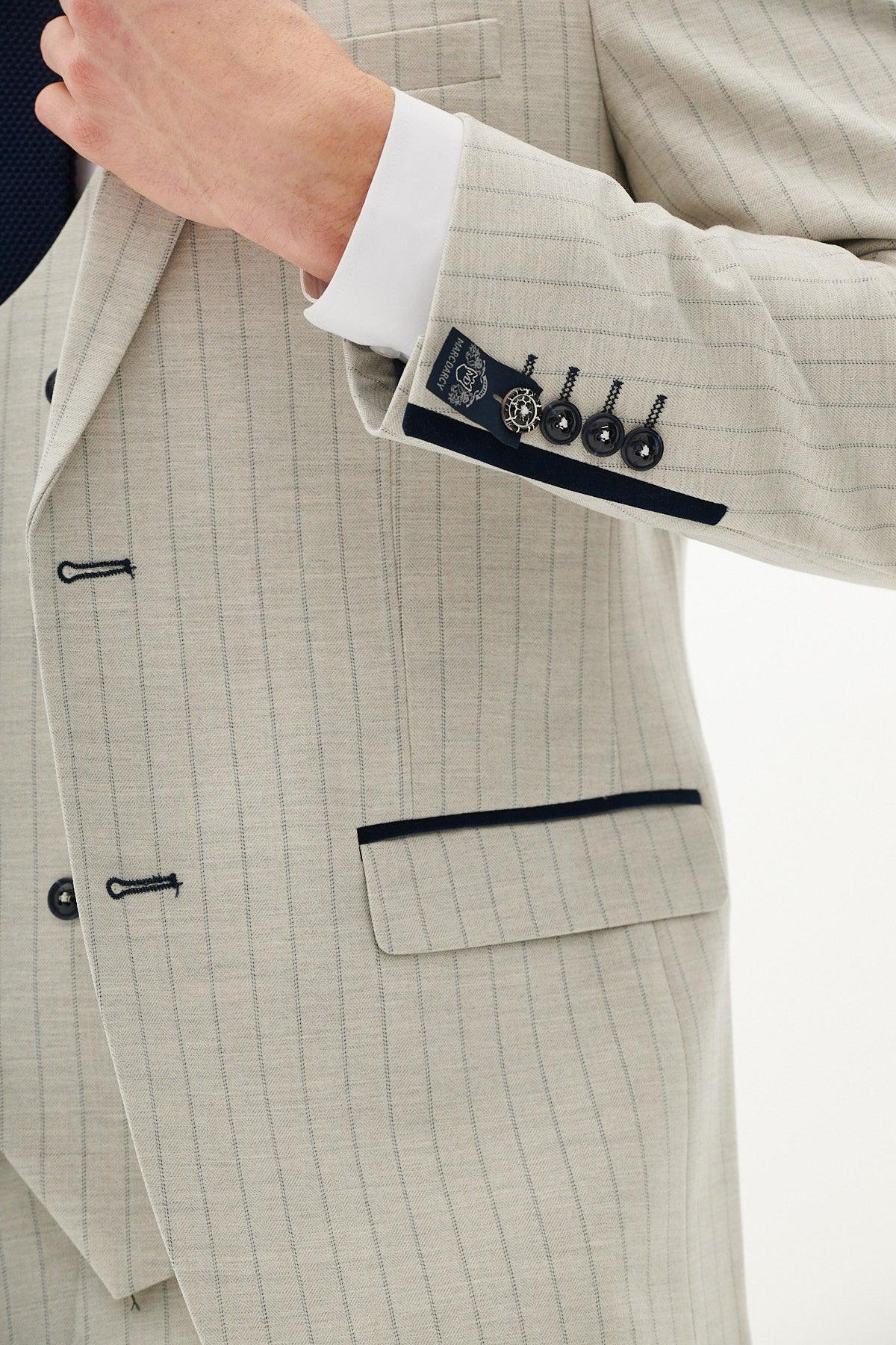 A person models the Marc Darcy GRANT - Stone Pinstripe Double Breasted Suit, featuring black buttons and pocket trim, with detailed sleeve and cuff stitching visible. Only the torso and one arm are shown.