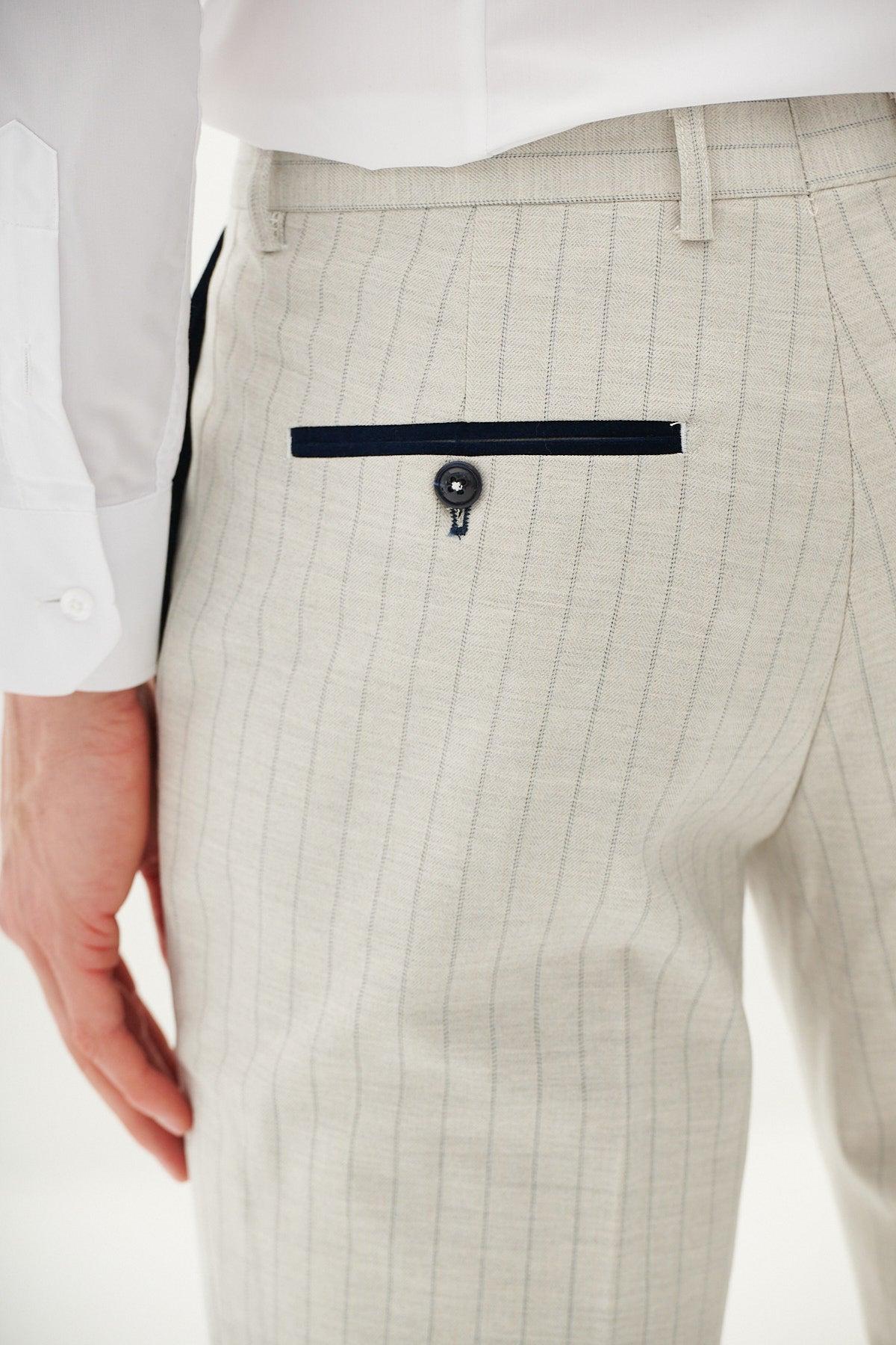 Close-up of Marc Darcy's GRANT Stone Pinstripe Trousers for men, featuring a navy trim welt pocket and a dark button.