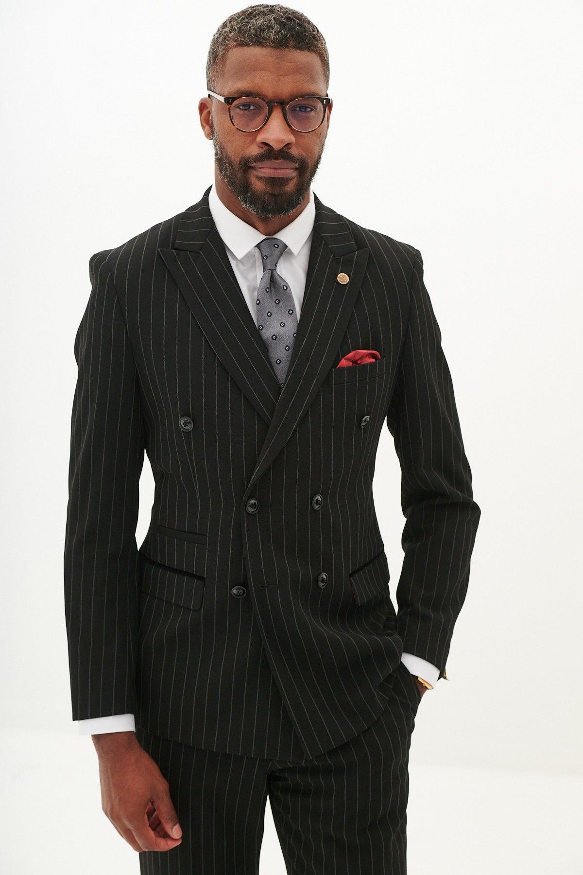 A man in the Marc Darcy ROCCO Black Pinstripe Double Breasted Blazer, a white dress shirt, patterned tie, red pocket square, and glasses stands confidently against a plain white background.