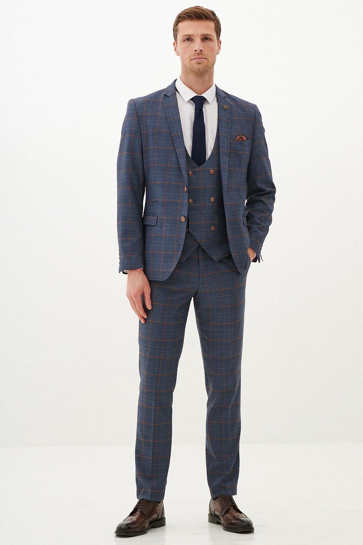 A man in the marcdarcy JENSON Sky Blue Check Suit with Double Breasted Waistcoat poses against a white background, styled with a slim fit blazer, white shirt, and navy tie.