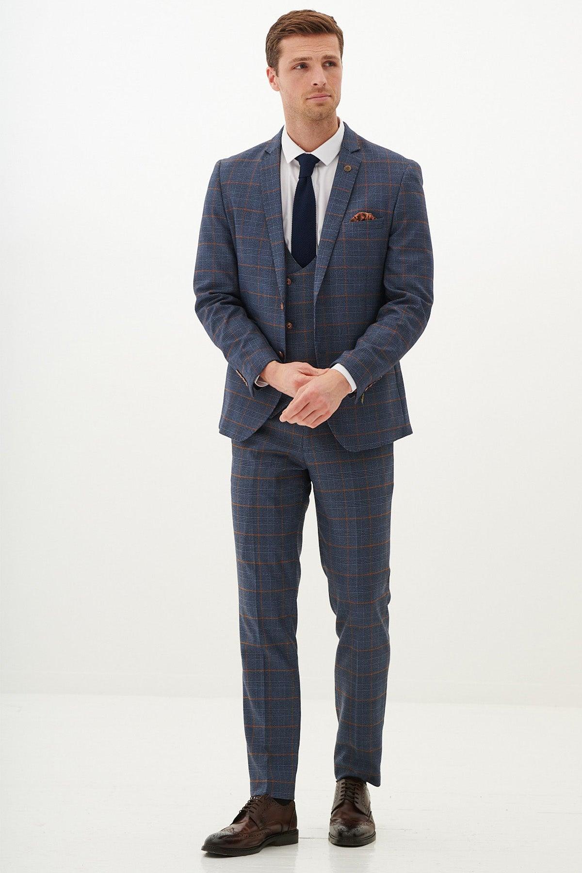 A man wears the marcdarcy JENSON Sky Blue Check Suit with Double Breasted Waistcoat, styled with a navy tie and pocket square.