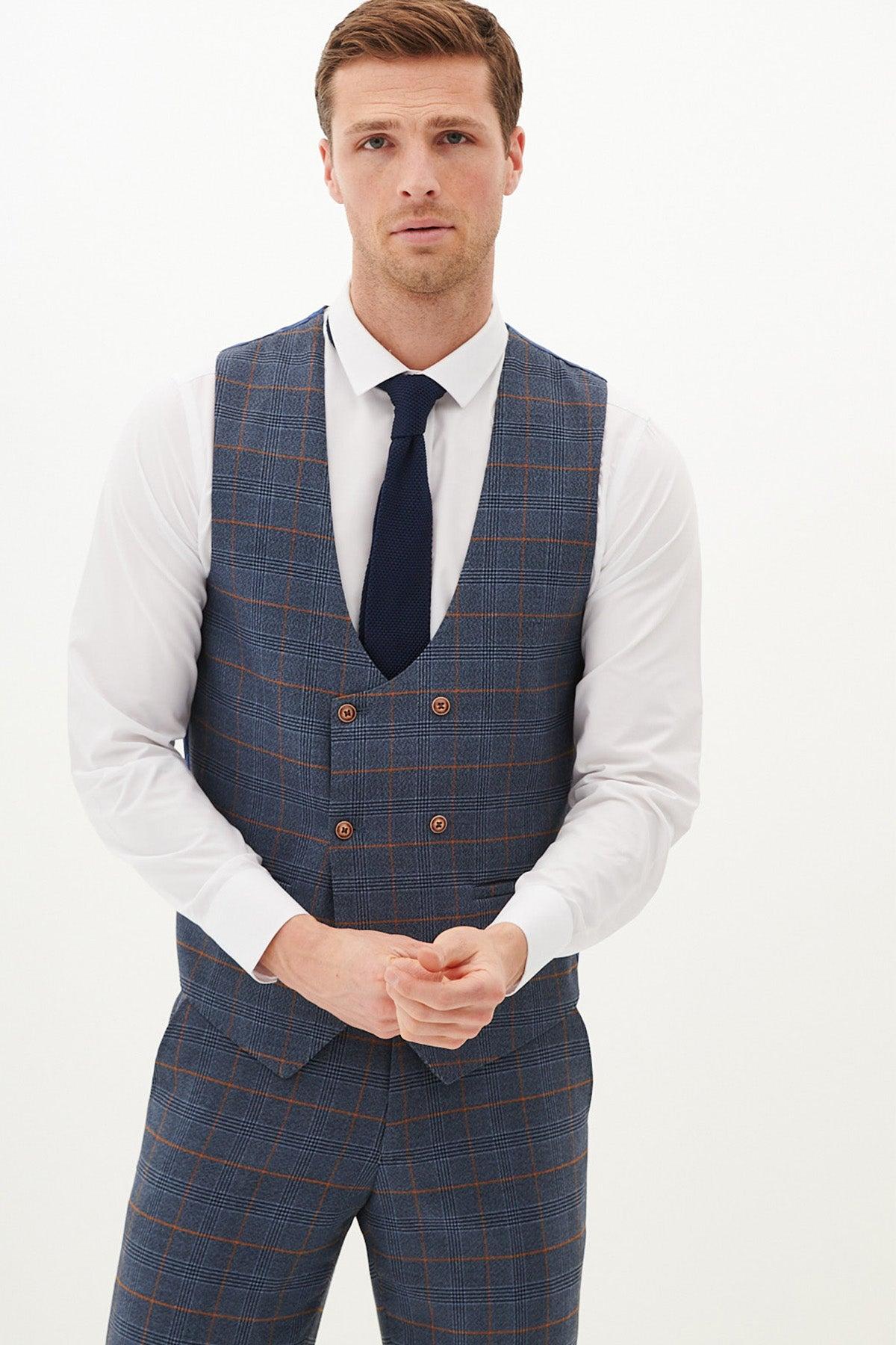 A man wearing a white dress shirt, navy tie, and the marcdarcy JENSON Sky Blue Check Double Breasted Waistcoat with matching trousers stands against a plain white background, looking directly at the camera with a neutral expression.