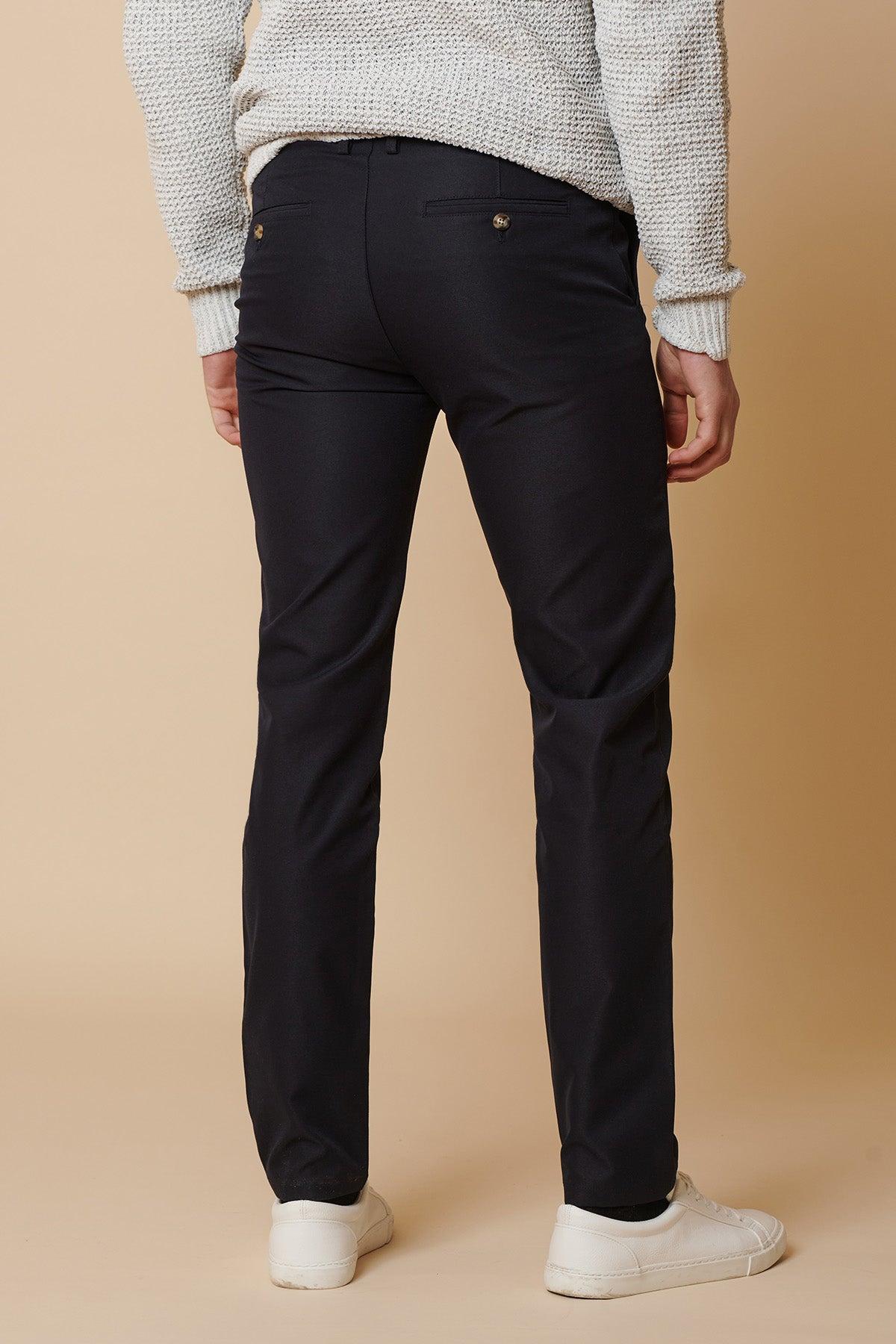 Back view of a man wearing marcdarcy ENZO Navy Chinos and a light gray sweater, standing on a plain background.