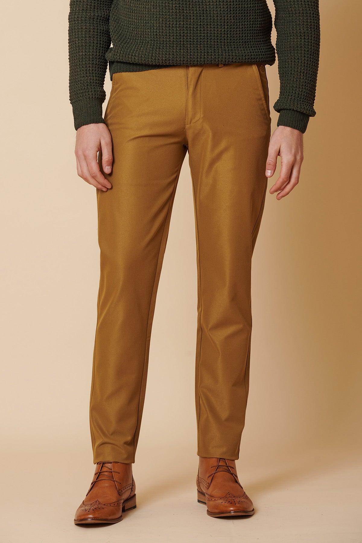 A man wears marcdarcy ENZO Tan Chinos paired with a dark green textured sweater and brown wingtip boots.