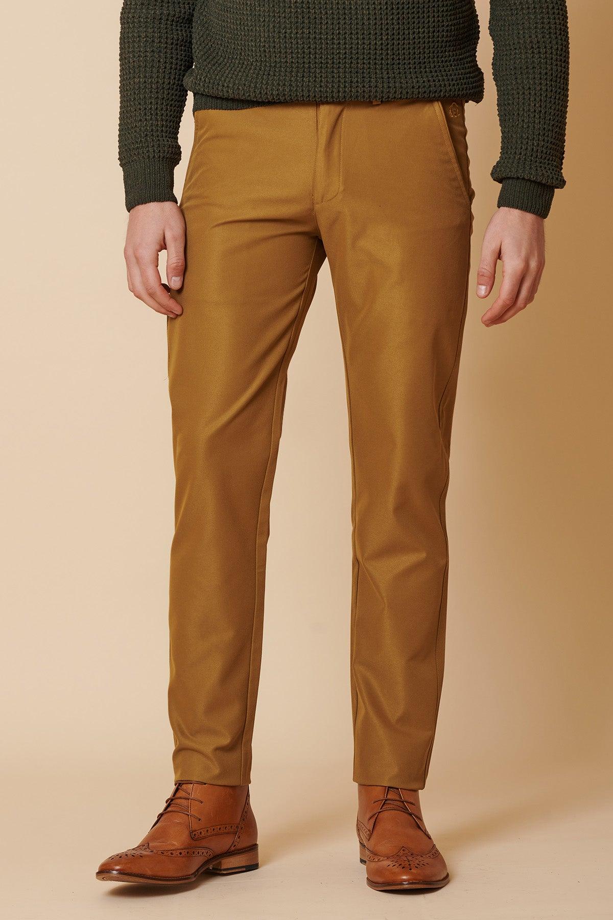 A man wears a dark green sweater, marcdarcy ENZO tan chinos, and brown wingtip boots.
