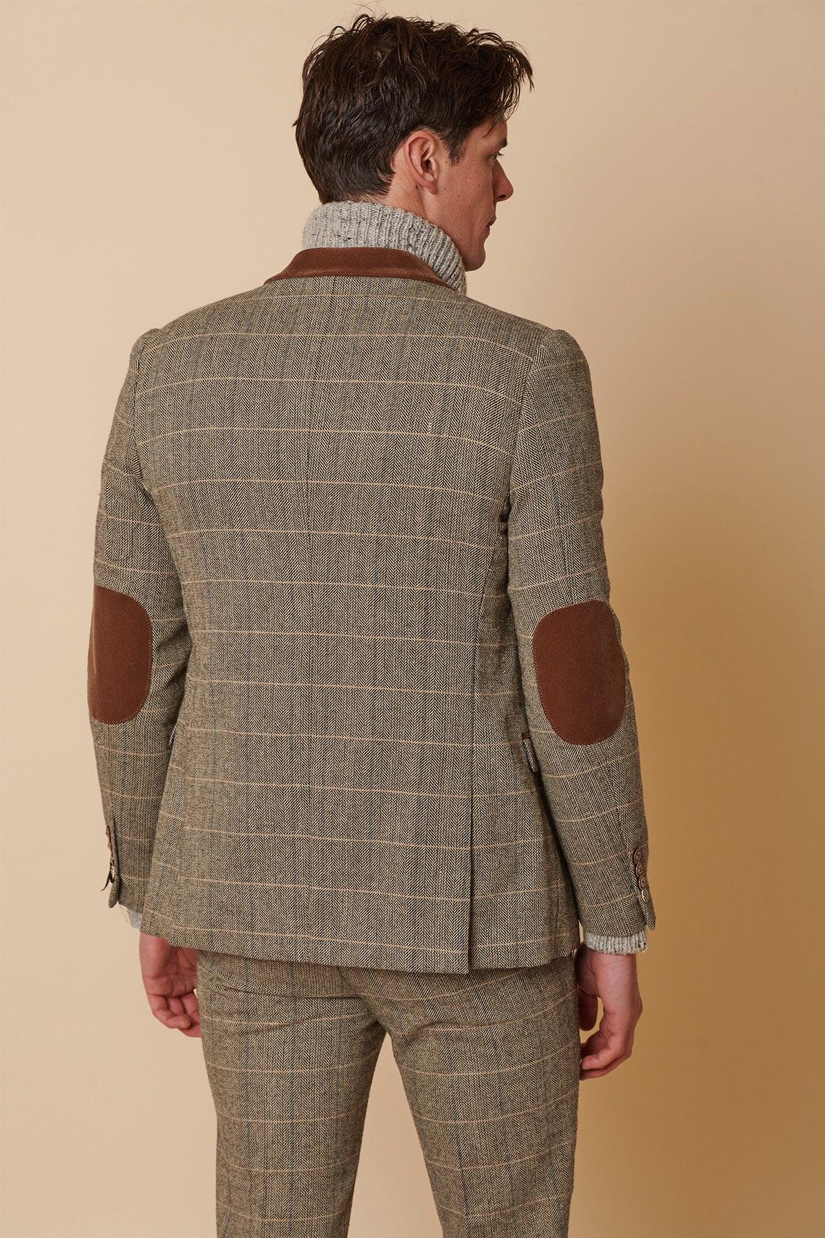 A man seen from the back wears the marcdarcy DX7 Tan Tweed Check Two Piece Suit, styled in an English heritage look with slim fit tailoring and a grey turtleneck sweater.