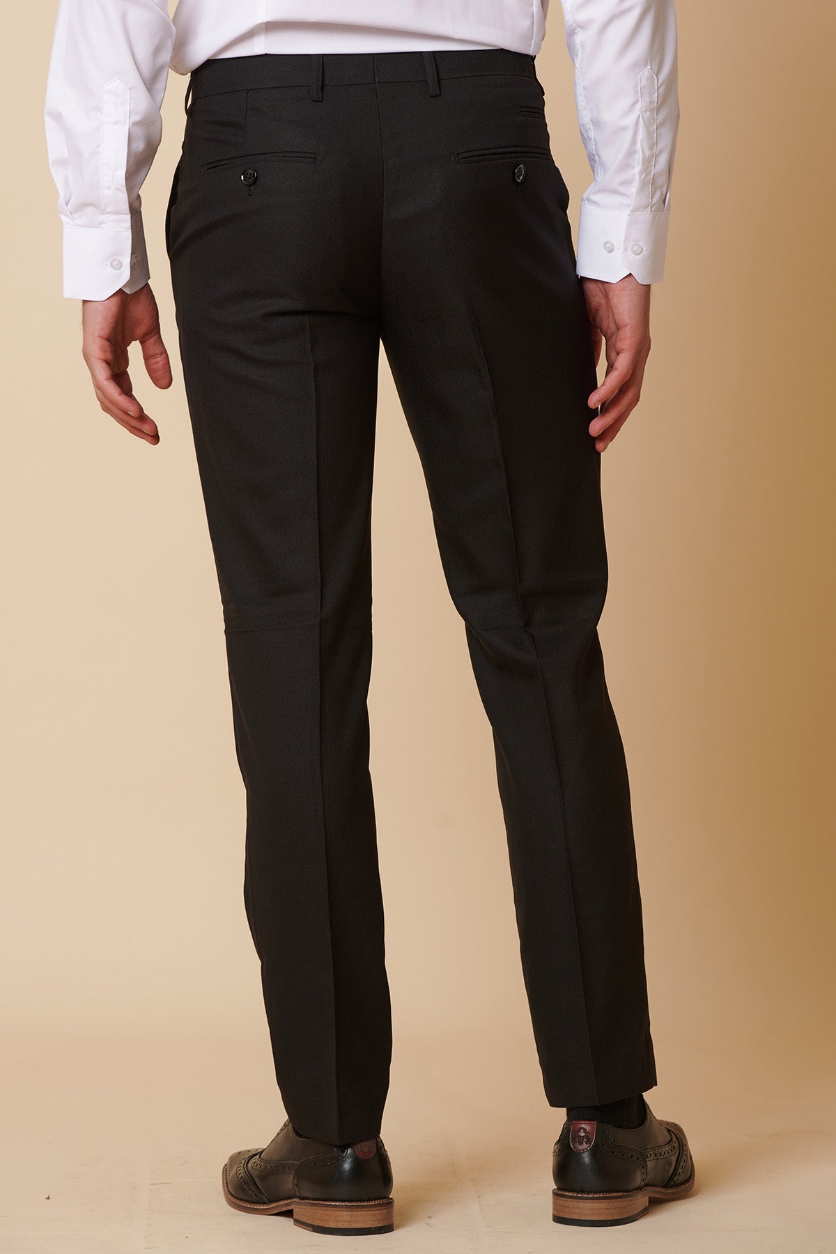 A man is shown from the back, standing against a beige background, wearing the Marc Darcy DANNY Black Three Piece Suit with Single Breasted Waistcoat.