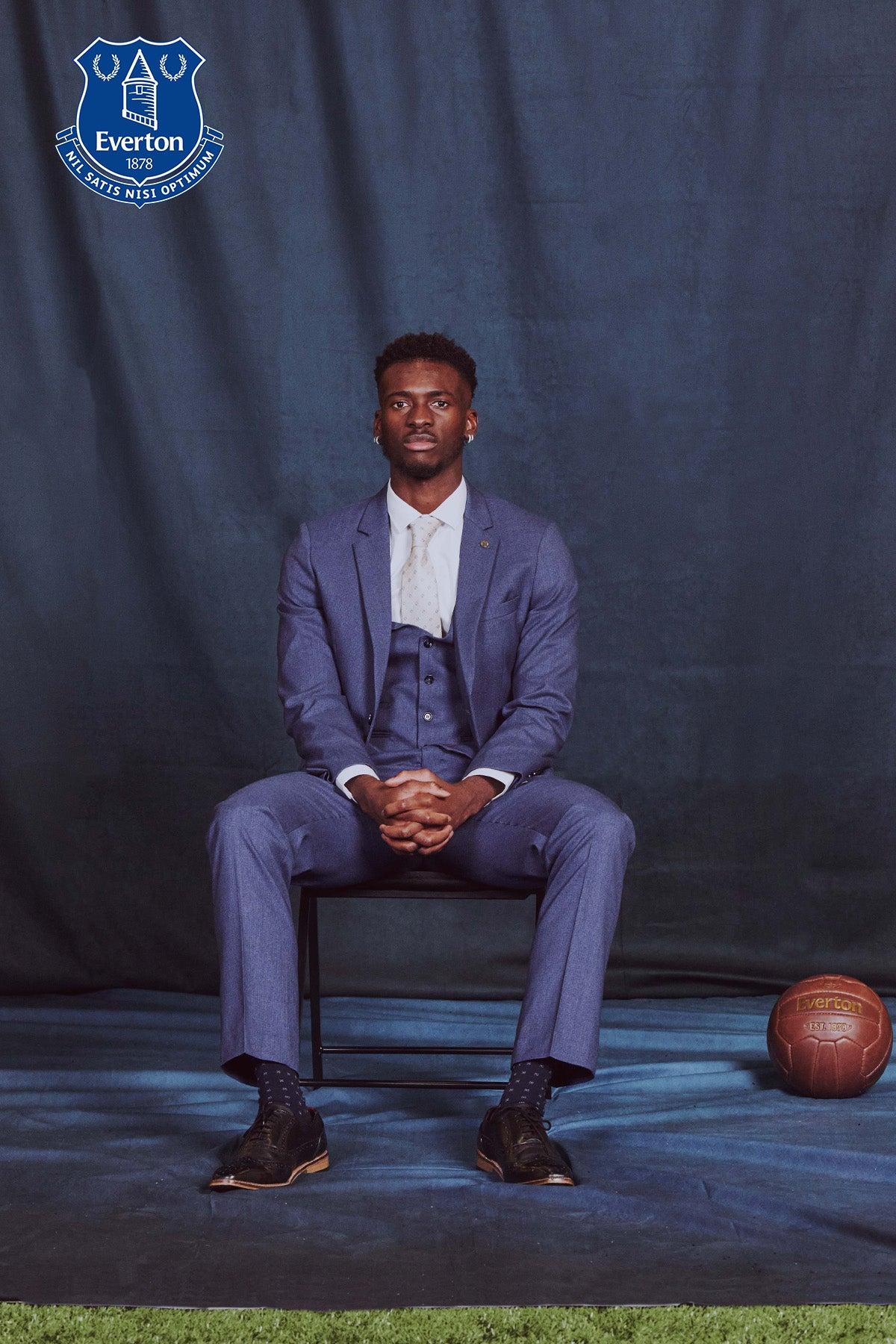 Tim Iroegbunam showcases the Marc Darcy ASHLEY Navy Blue Three Piece Suit from The Everton Collection, featuring the club crest and a classic football.