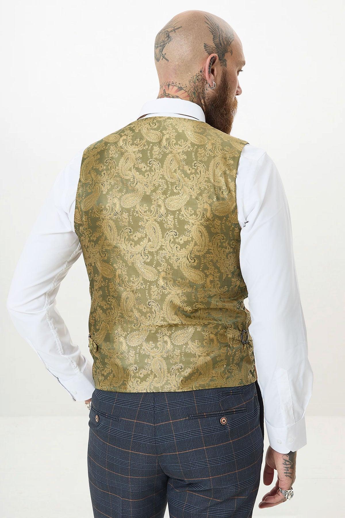 A bald, tattooed man is seen from behind wearing a white shirt, the Kelvin Tan waistcoat, and marine navy check suit trousers from the marcdarcy JENSON collection against a plain light background.