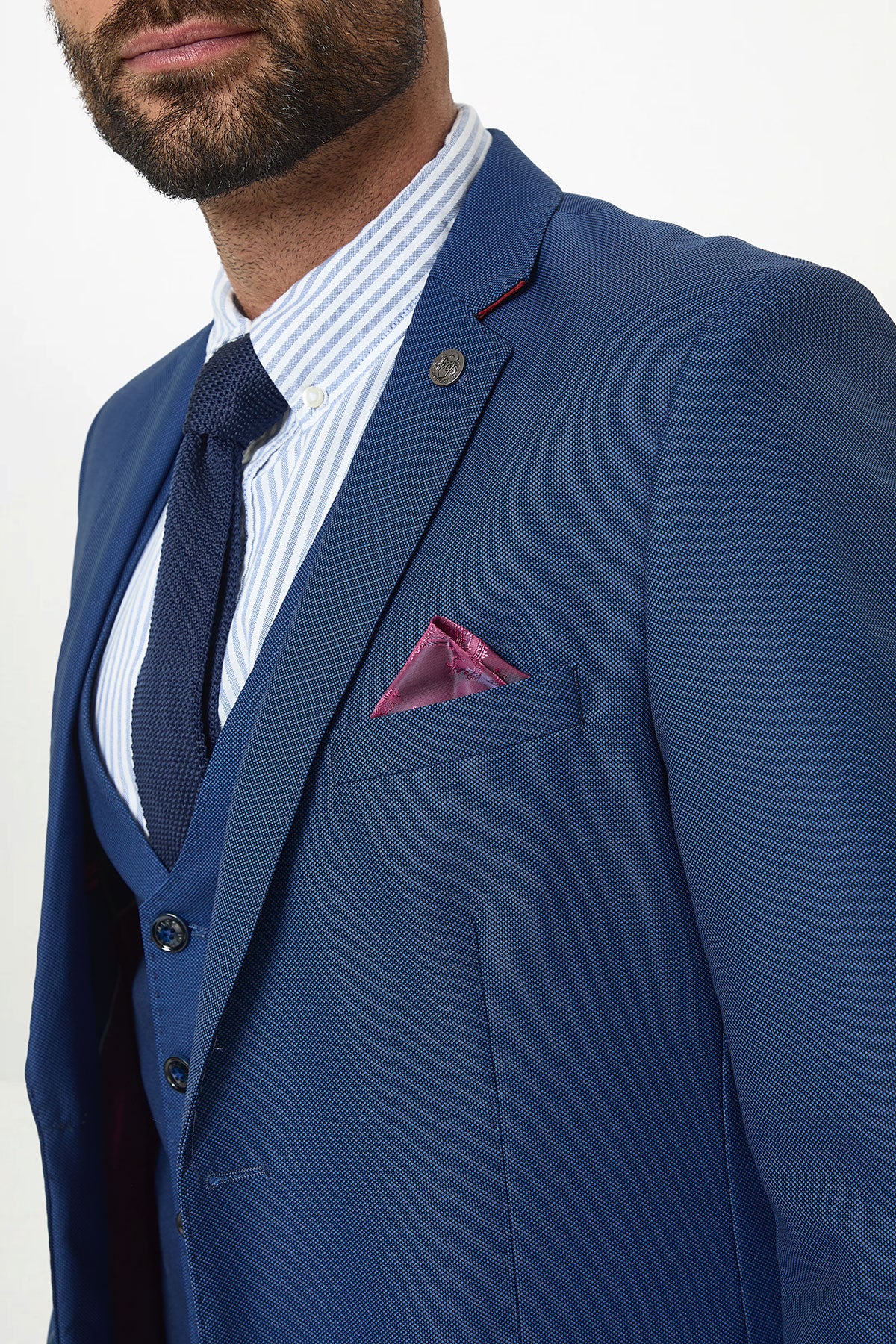 A man wears the Marc Darcy DANNY Royal Blue Tailored Blazer with a white and blue striped shirt, navy tie, and purple pocket square—ideal for workwear. Only his upper torso and part of his face are visible against a white background.