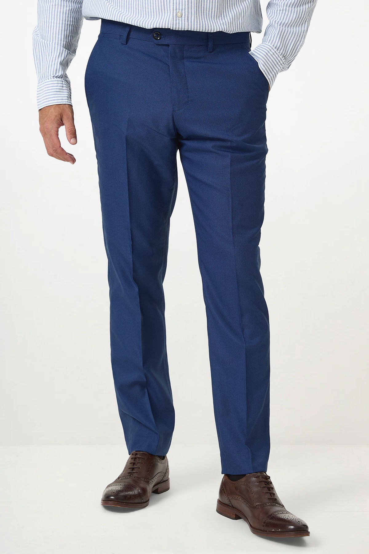 A man models Marc Darcy's DANNY Royal Blue Tailored Trousers with a light blue striped shirt and brown leather dress shoes, standing against a plain white background with his hands relaxed by his sides.