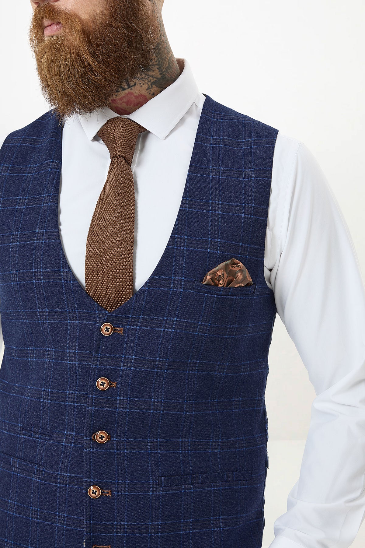 Man wearing a marcdarcy CHIGWELL Blue Tweed Check Waistcoat, white shirt, brown knit tie, and patterned pocket square.