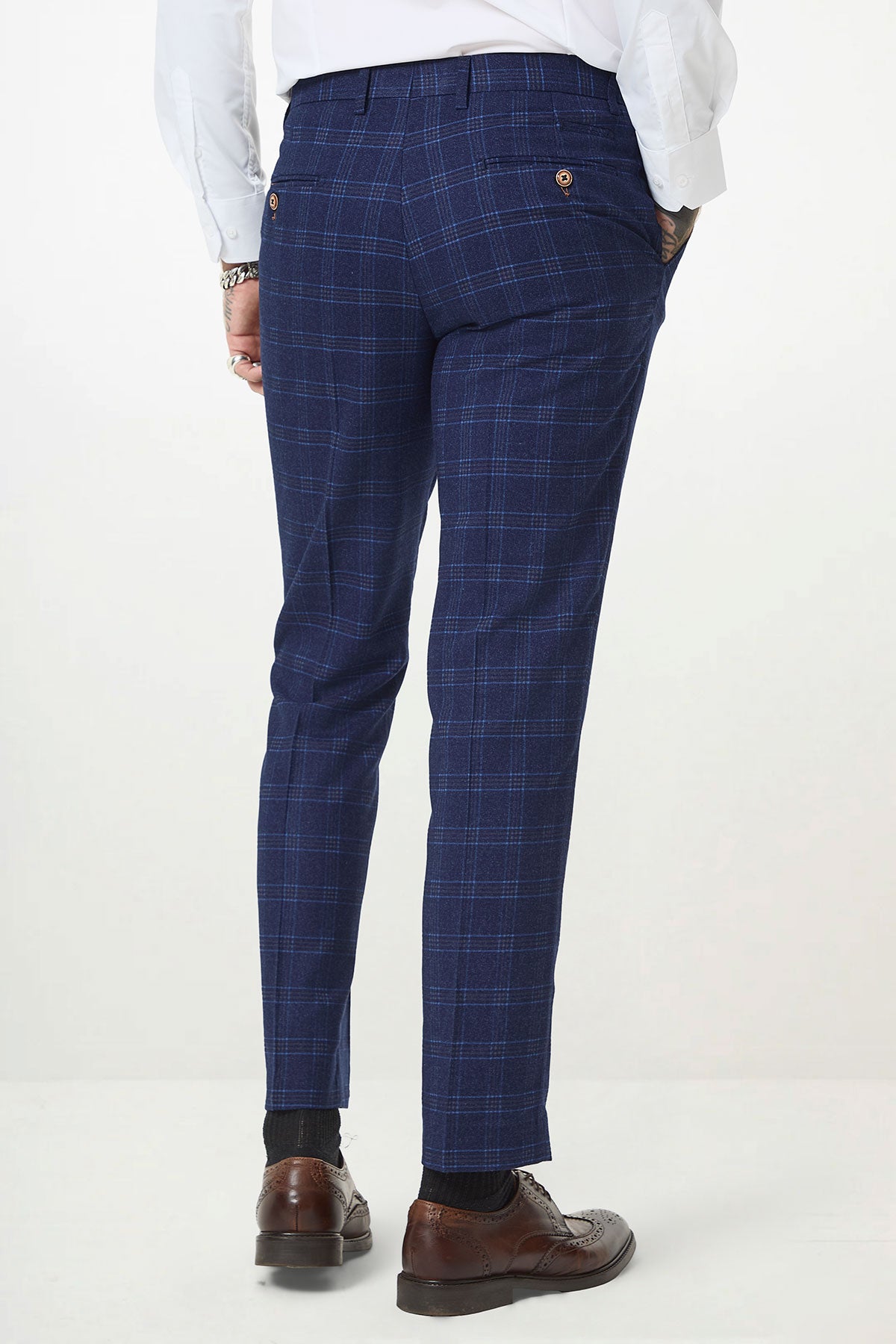 Rear close-up of a man in marcdarcy's CHIGWELL Blue Tweed Check Trousers, paired with a white shirt and brown wingtip shoes, set against a white background.