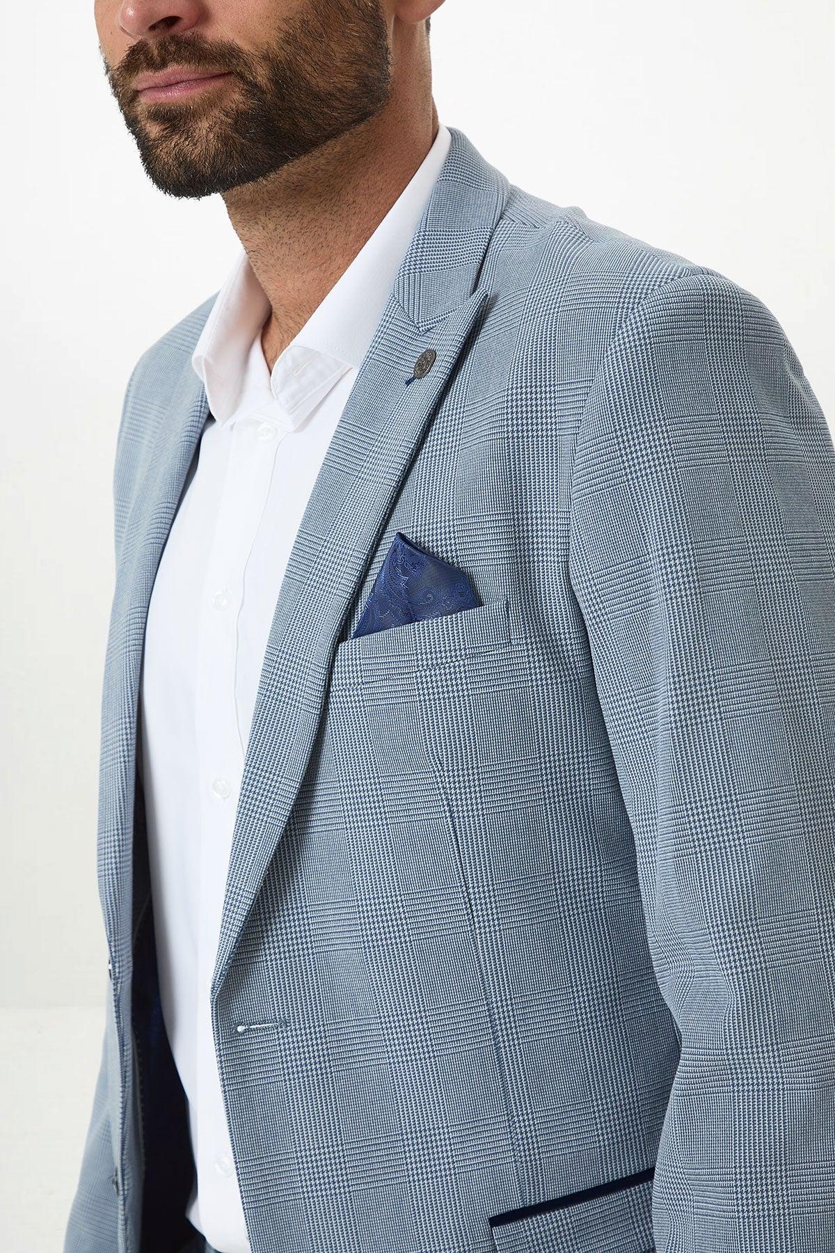 A man wearing the Marc Darcy BROMLEY Sky Blue Check Two Piece Suit with a white shirt and dark blue pocket square, shown from the shoulders up against a plain white background.