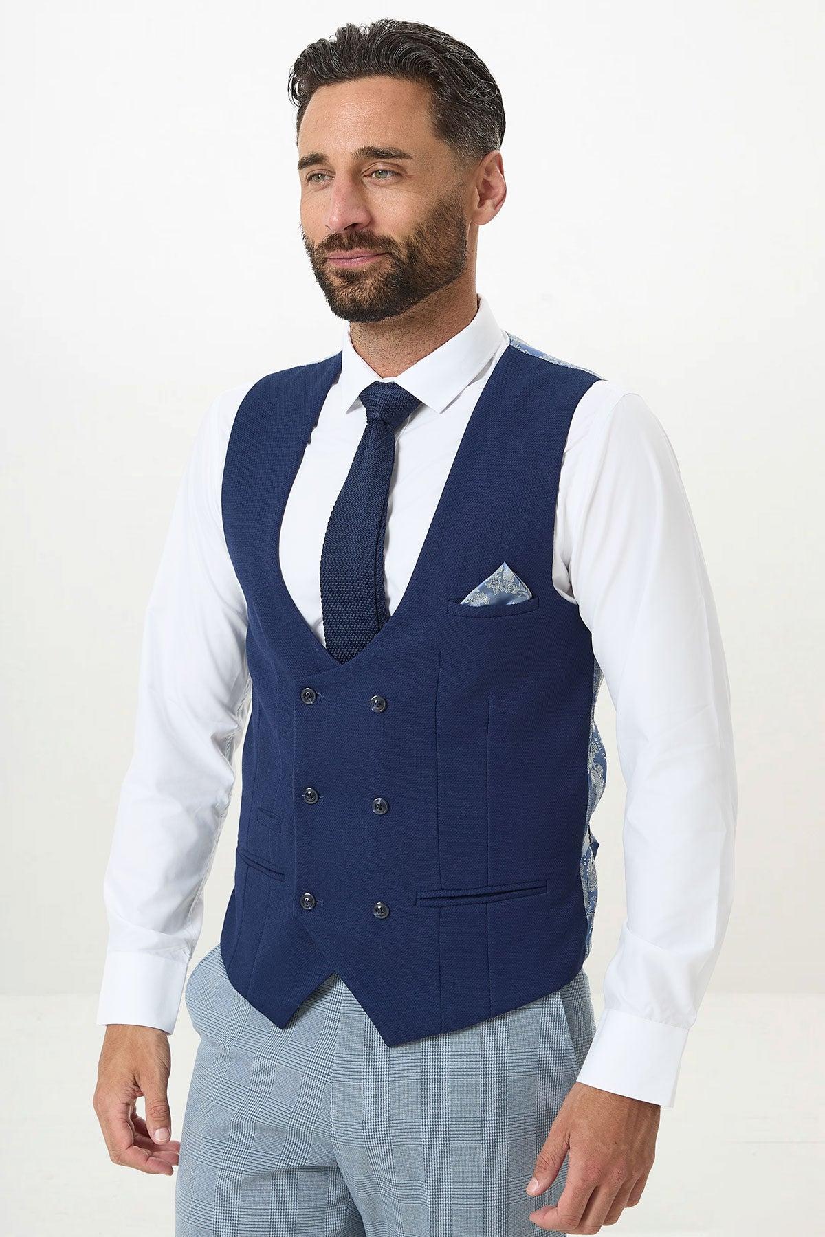 A man with dark hair and a beard wears the Marc Darcy BROMLEY - Sky Check Suit with Kelvin Royal Waistcoat. He pairs it with a white shirt, blue tie, and pocket square, standing against a plain white background.