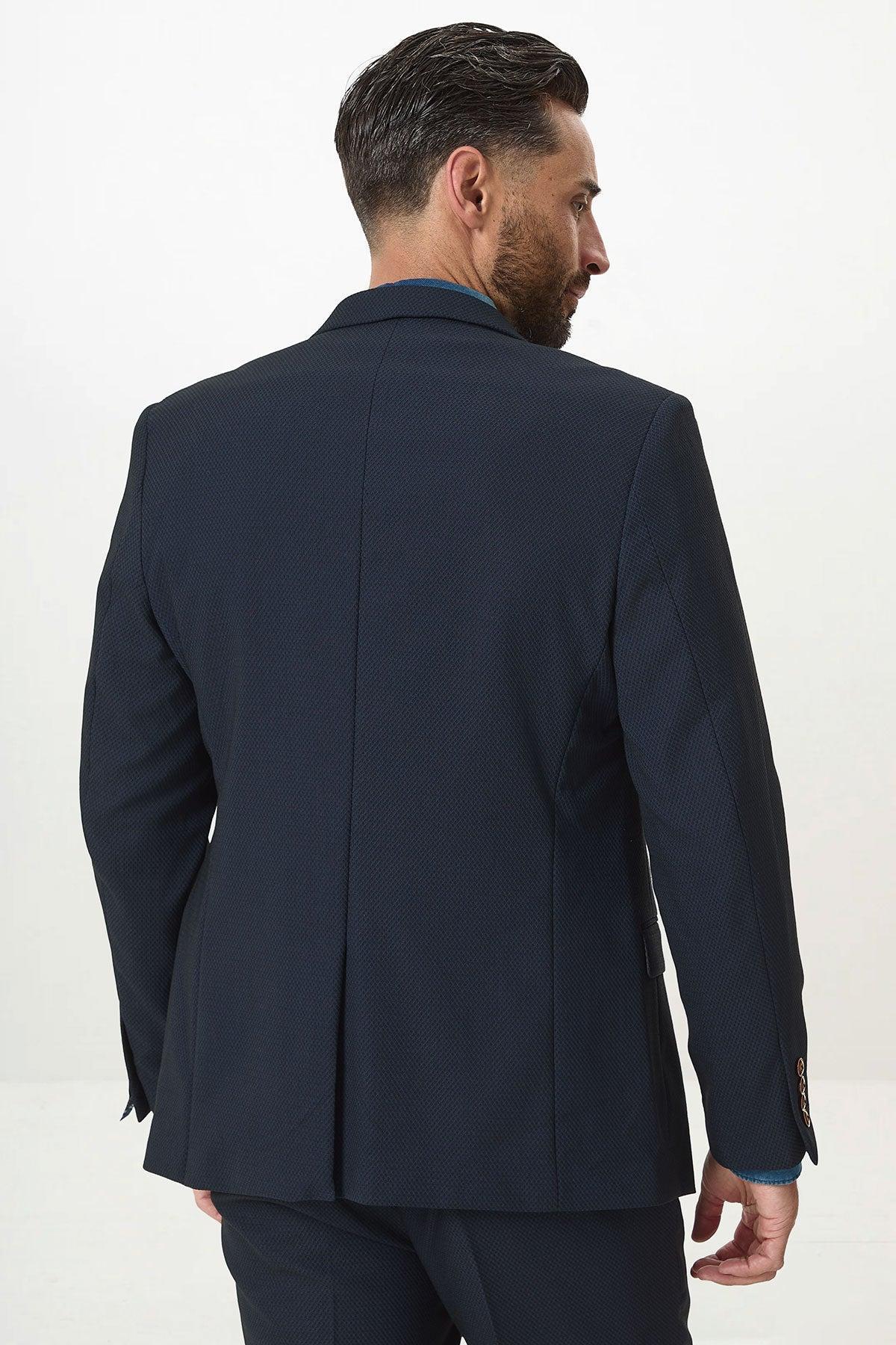 A man with short dark hair and a trimmed beard is wearing the marcdarcy MAX Navy Blue Blazer with Contrast Buttons, standing with his back to the camera against a plain white background—ideal for modern office wear.