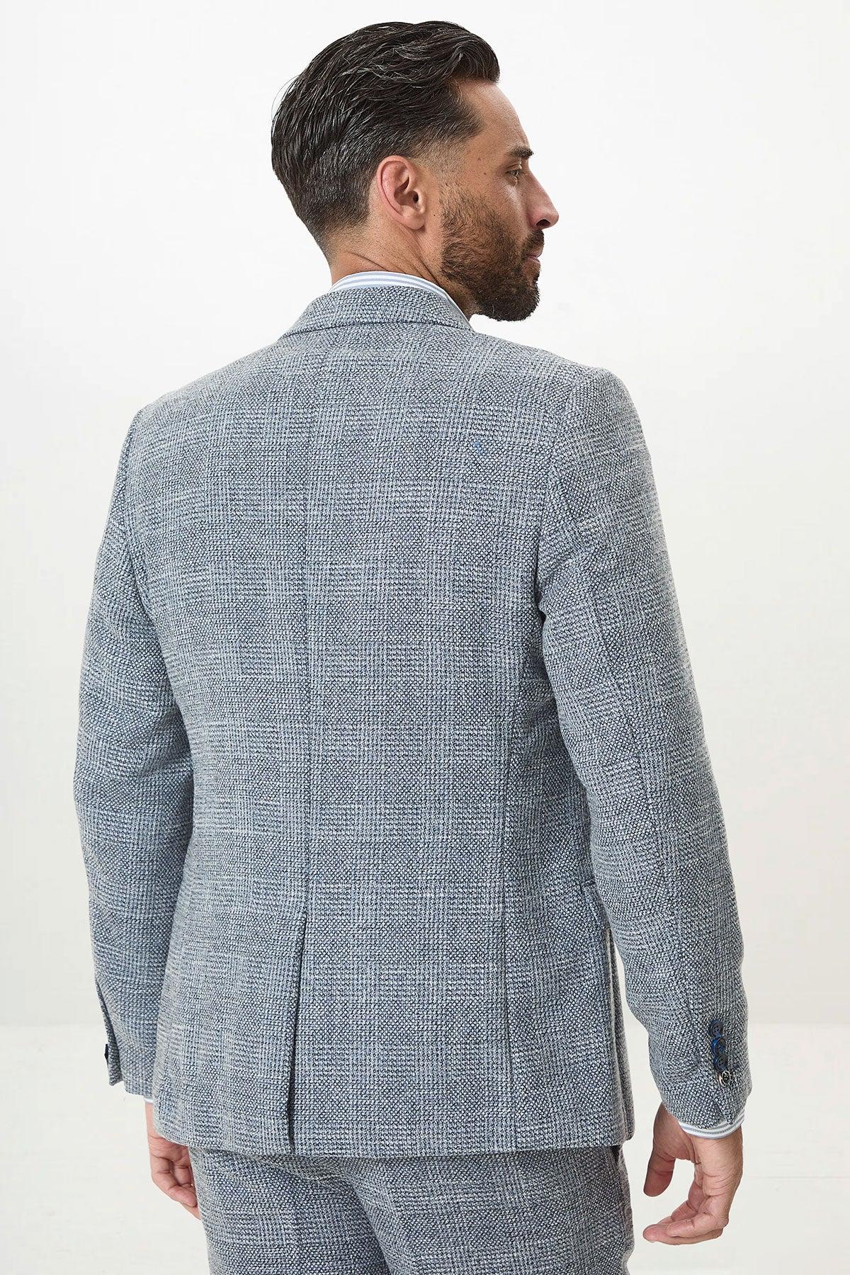 Back view of a man in the marcdarcy KRIS Sky Blue Tweed Two Piece Suit, featuring a slim fit blazer with center vent and button cuffs, matching trousers, and a light blue shirt.