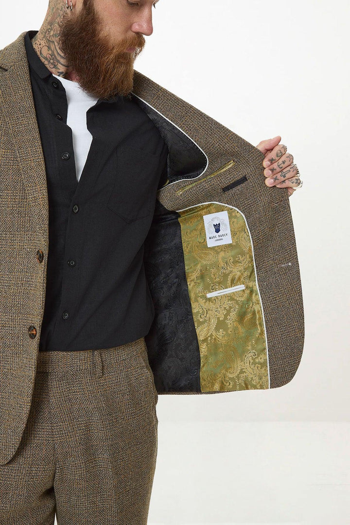 A man in a slim fit marcdarcy KRIS Tan Tweed Two Piece Suit reveals the jacket’s gold paisley patterned lining and the signature marcdarcy London label.