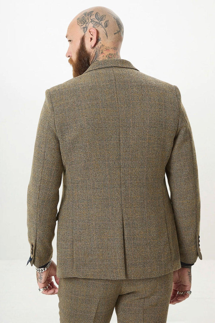 Back view of a tattooed man with a beard and hoop earring, showcasing modern style in the marcdarcy KRIS Tan Tweed Two Piece Suit featuring classic Prince of Wales check.