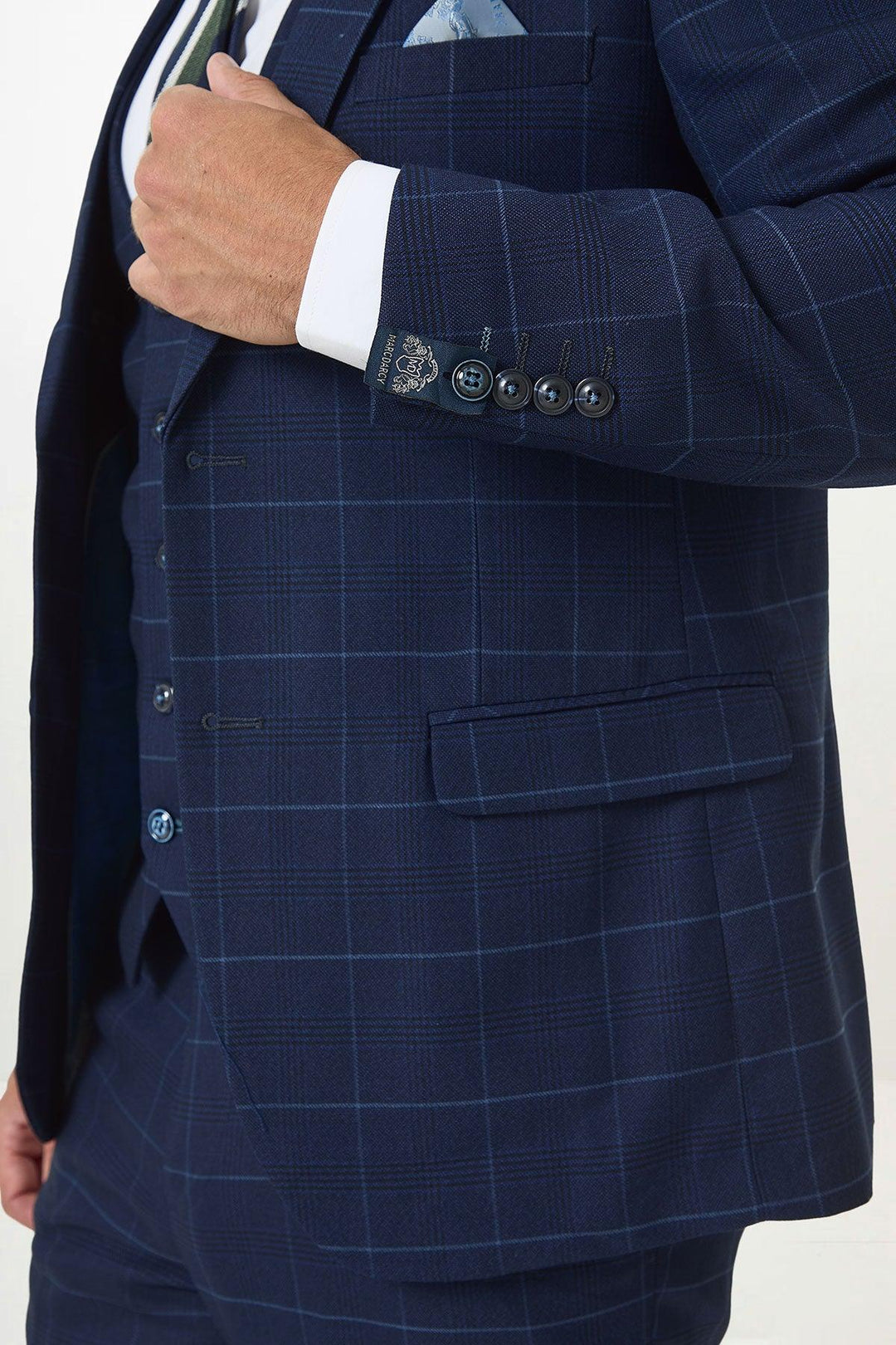 A person wears the Marc Darcy EDINSON Navy Sky Check Blazer, a slim tailored fit with windowpane pattern and pocket square, styled with a white dress shirt, patterned tie, and showing off the sleeve buttons and pocket.