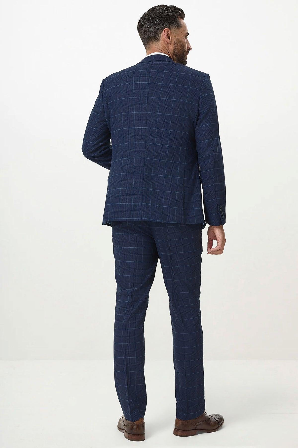 A man faces away, wearing the Marc Darcy EDINSON Navy Sky Check Three Piece Suit in a slim tailored fit with brown shoes, set against a plain white background.