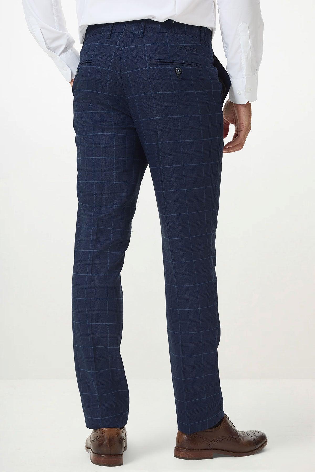 A person wearing the Marc Darcy EDINSON Navy Sky Check Three Piece Suit, featuring slim tailored fit pants, a white dress shirt, and brown dress shoes, is shown from the back against a plain light background.