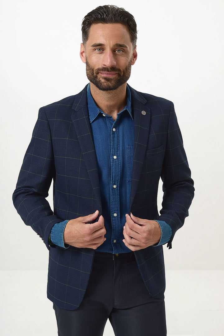 A man with dark hair and a beard models the Marc Darcy EDINSON Navy Green Check Blazer over a denim shirt, standing against a white background and looking confidently at the camera.