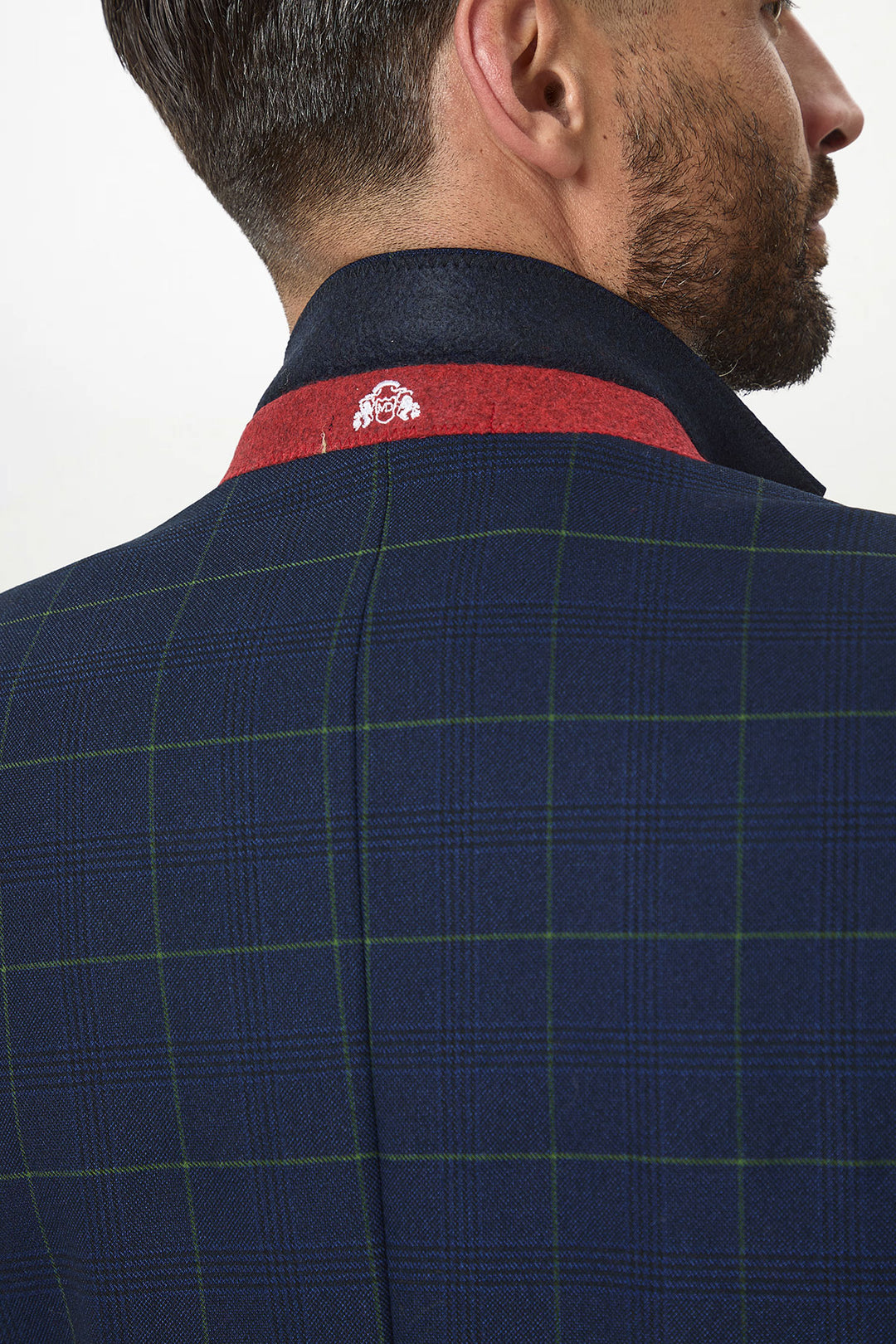 A close-up of a mans back and neck wearing the Marc Darcy EDINSON Navy Green Check Blazer, a slim tailored fit in navy plaid with green lines, dark collar with red inner lining, and a small white embroidered emblem.