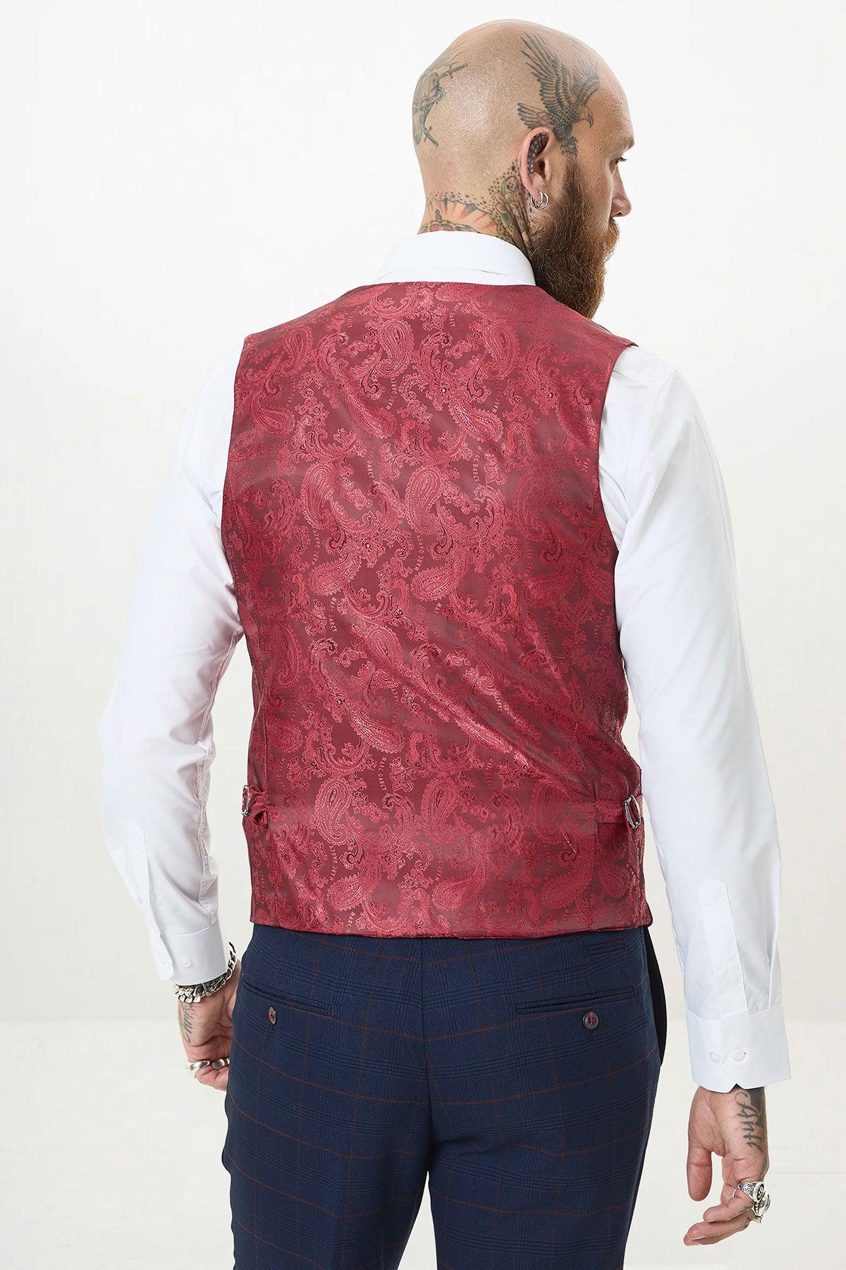 A bald man with a beard, in a white shirt, blue plaid trousers, and the marcdarcy KELVIN - Wine Single Breasted Waistcoat with an ornate red paisley design, is shown from the back against a plain light background.