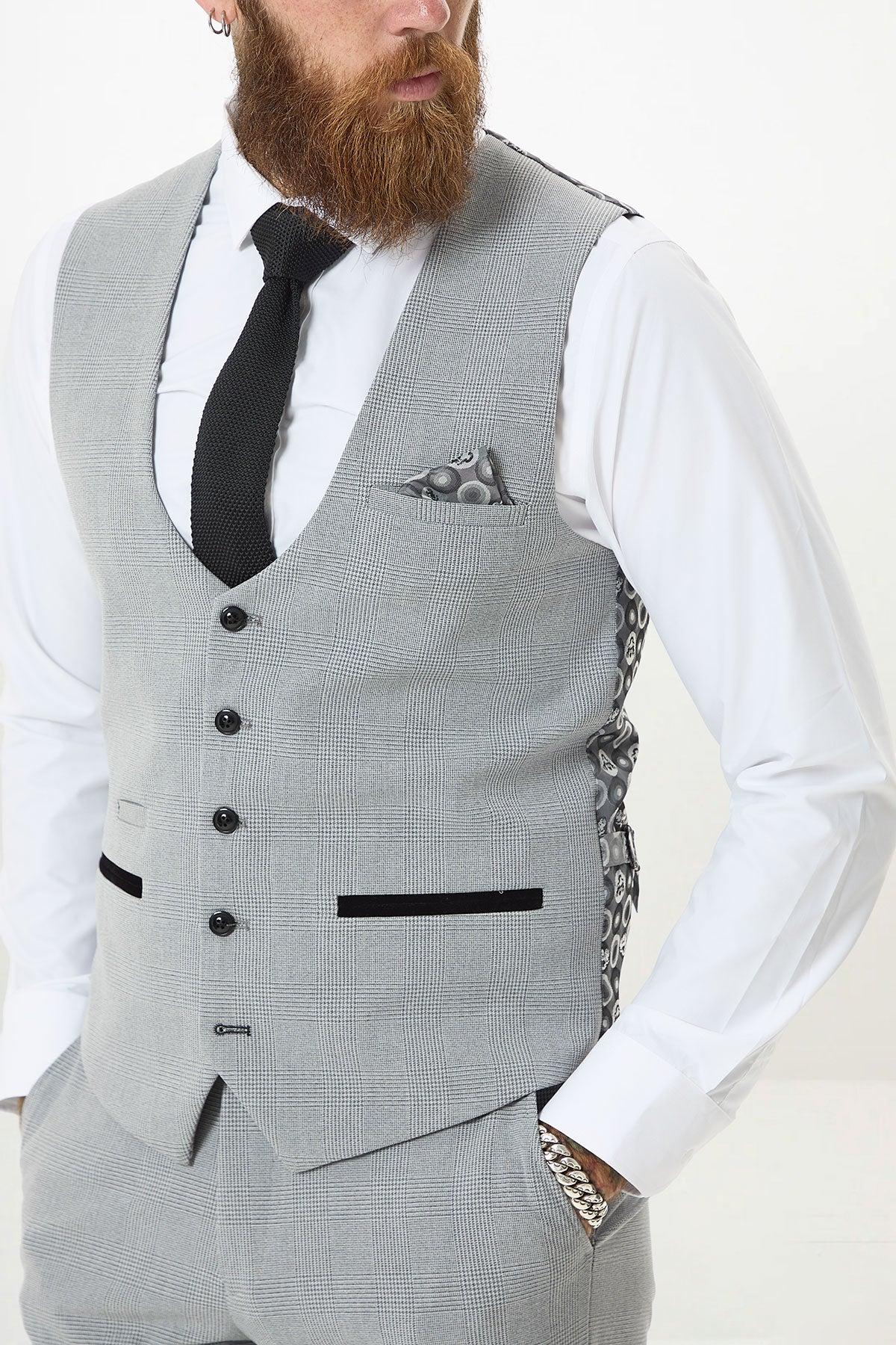 A man wears the Marc Darcy BROMLEY Silver Grey Single Breasted Check Waistcoat with matching pants, a white shirt, black tie, and pocket square. Only his bearded face and torso are visible.