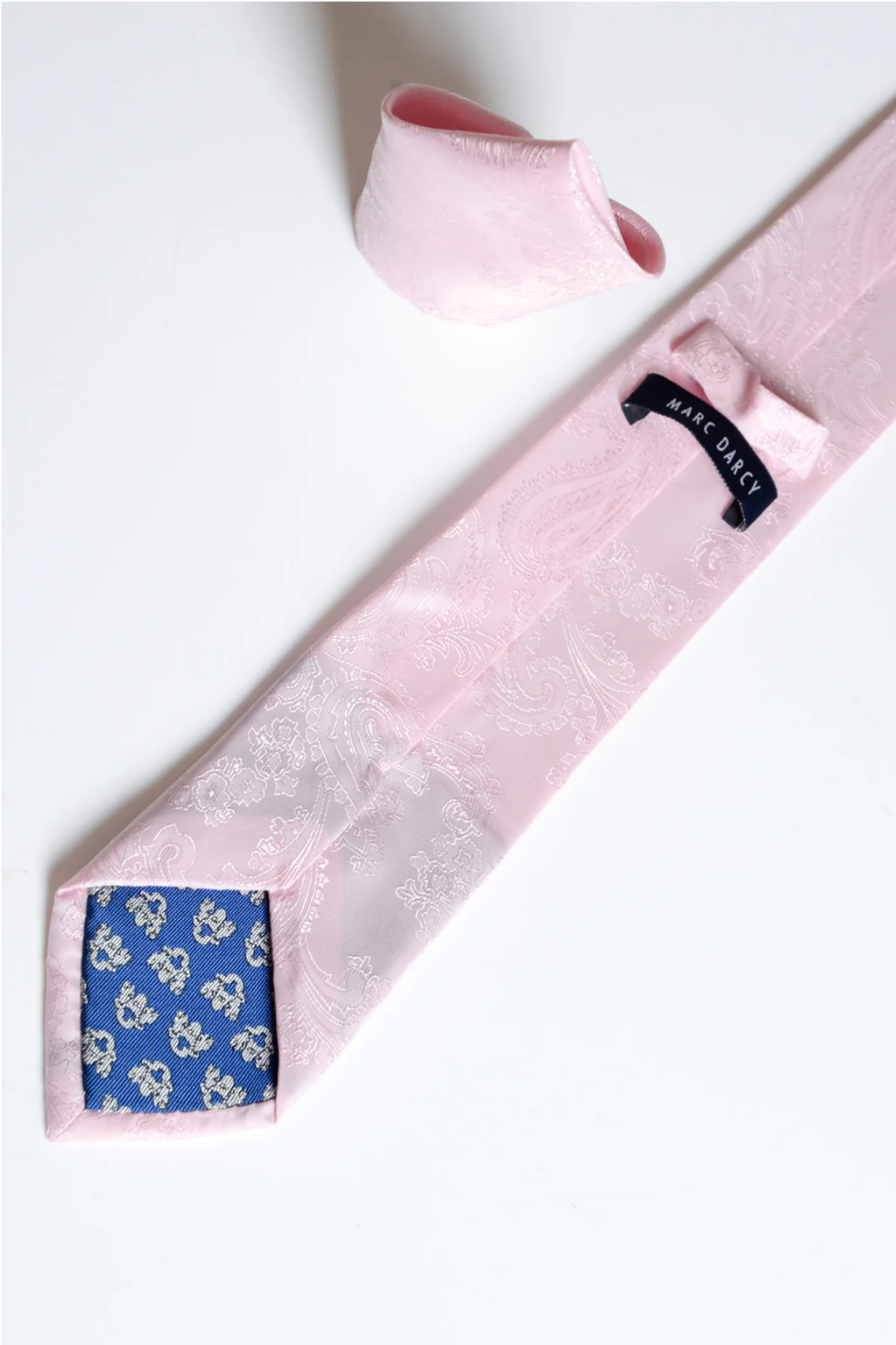 The Accessory MD PAISLEY Light Pink Paisley Tie and Pocket Square Set features a matching pair with visible blue floral lining, elegantly displayed on a white background.