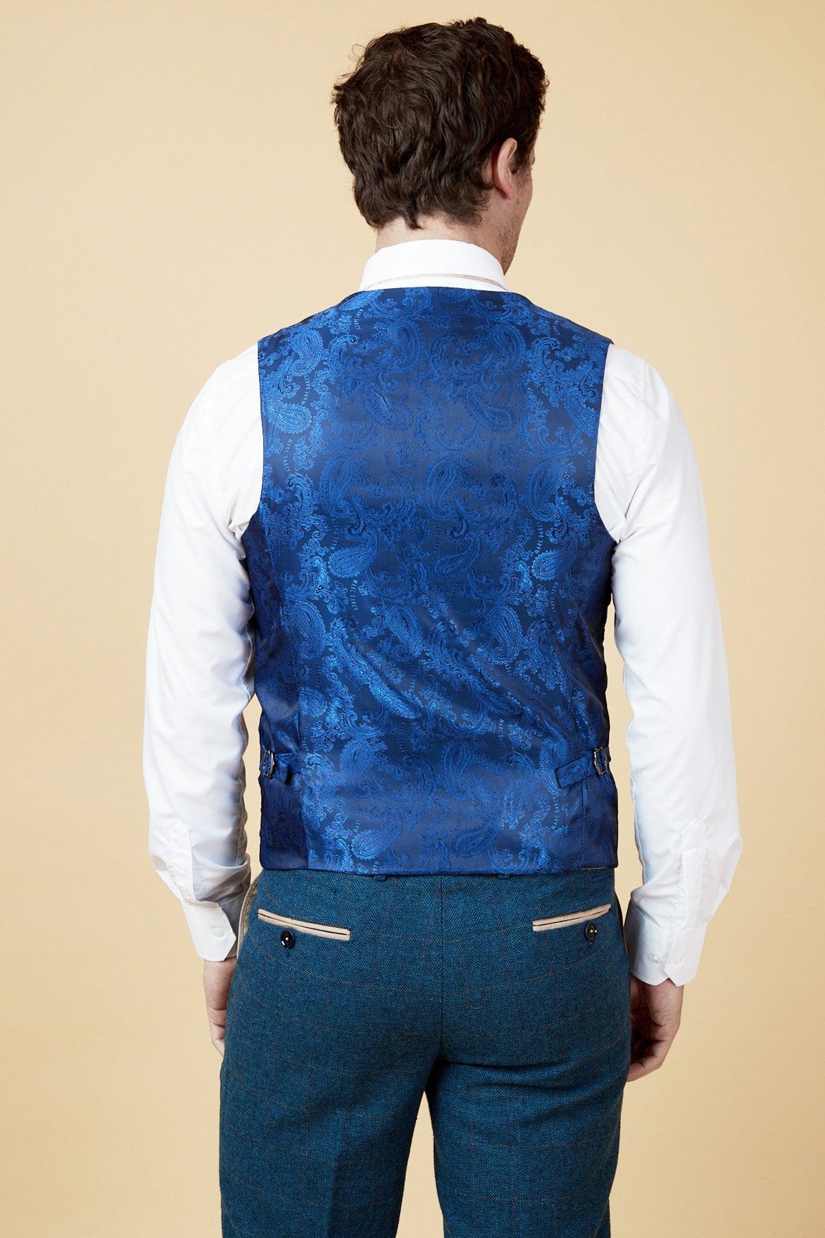 Back view of a man wearing marcdarcy’s WHU Collection—TED Tan Tweed Suit with Dion Waistcoat as worn by Lukasz Fabianski—capturing refined English gent style.