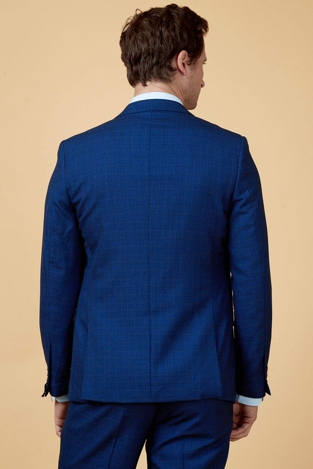 Man wears the marcdarcy GEORGE - Royal Blue Check Blazer with a light blue dress shirt, back view—a sharp choice for any work wardrobe.