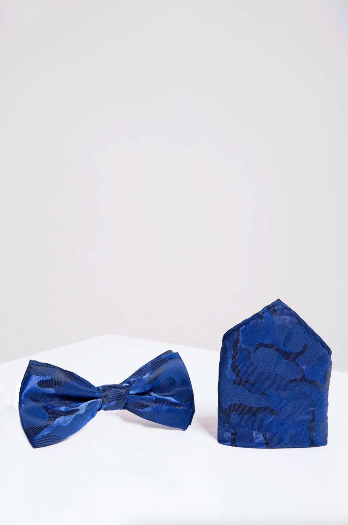 The Accessory BT ARMY - Blue Camouflage Bow Tie and Pocket Square Set is displayed side by side on a white surface with a light gray background.
