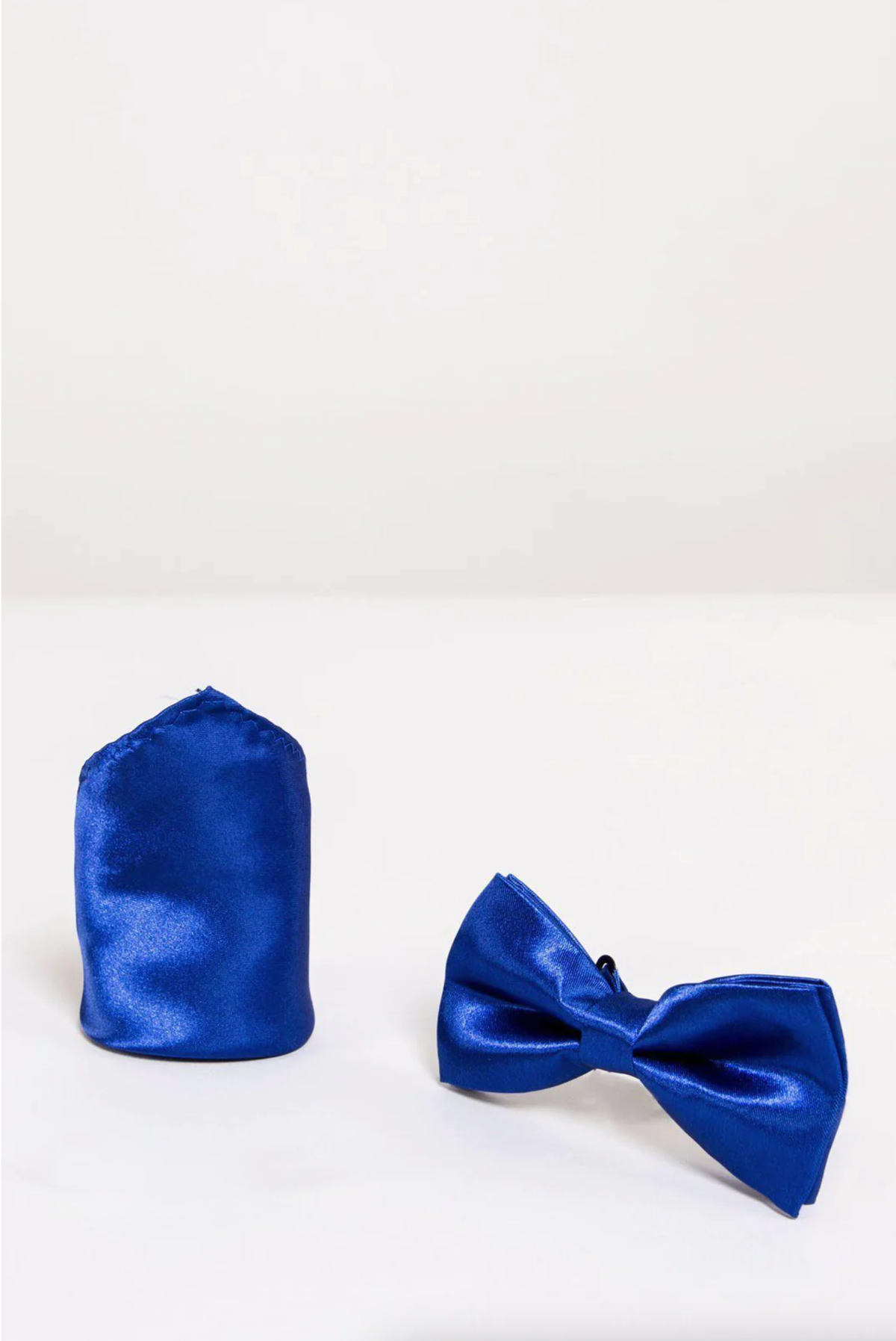 The Accessory SB - Satin Bow Tie and Pocket Square Set In Royal Blue pairs a matching satin bow tie with a pocket square, offering an elegant set perfect for formal occasions.